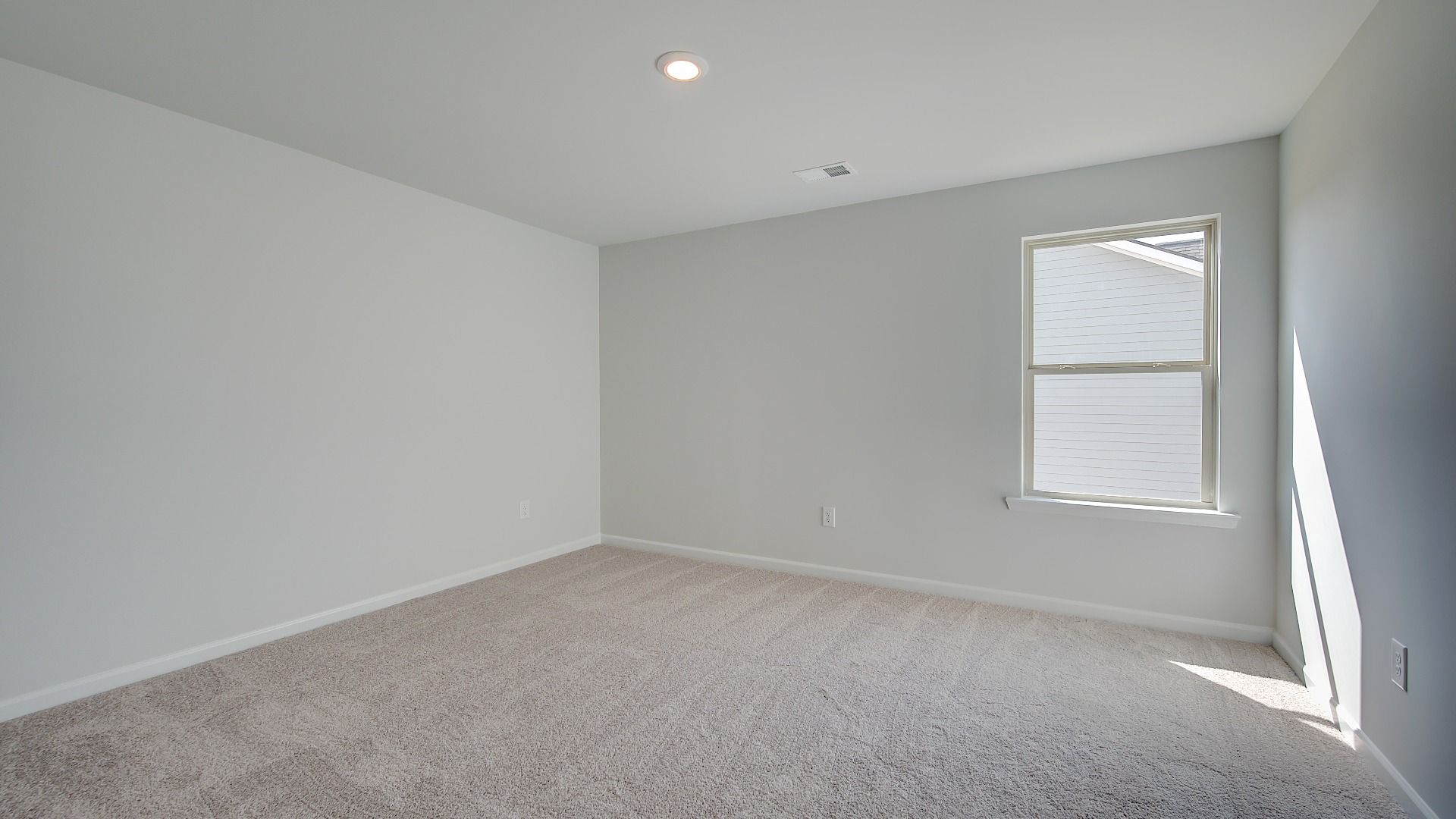 McKinley II generously sized secondary bedroom with carpet flooring and natural light at Brighton in Locust Grove, GA.