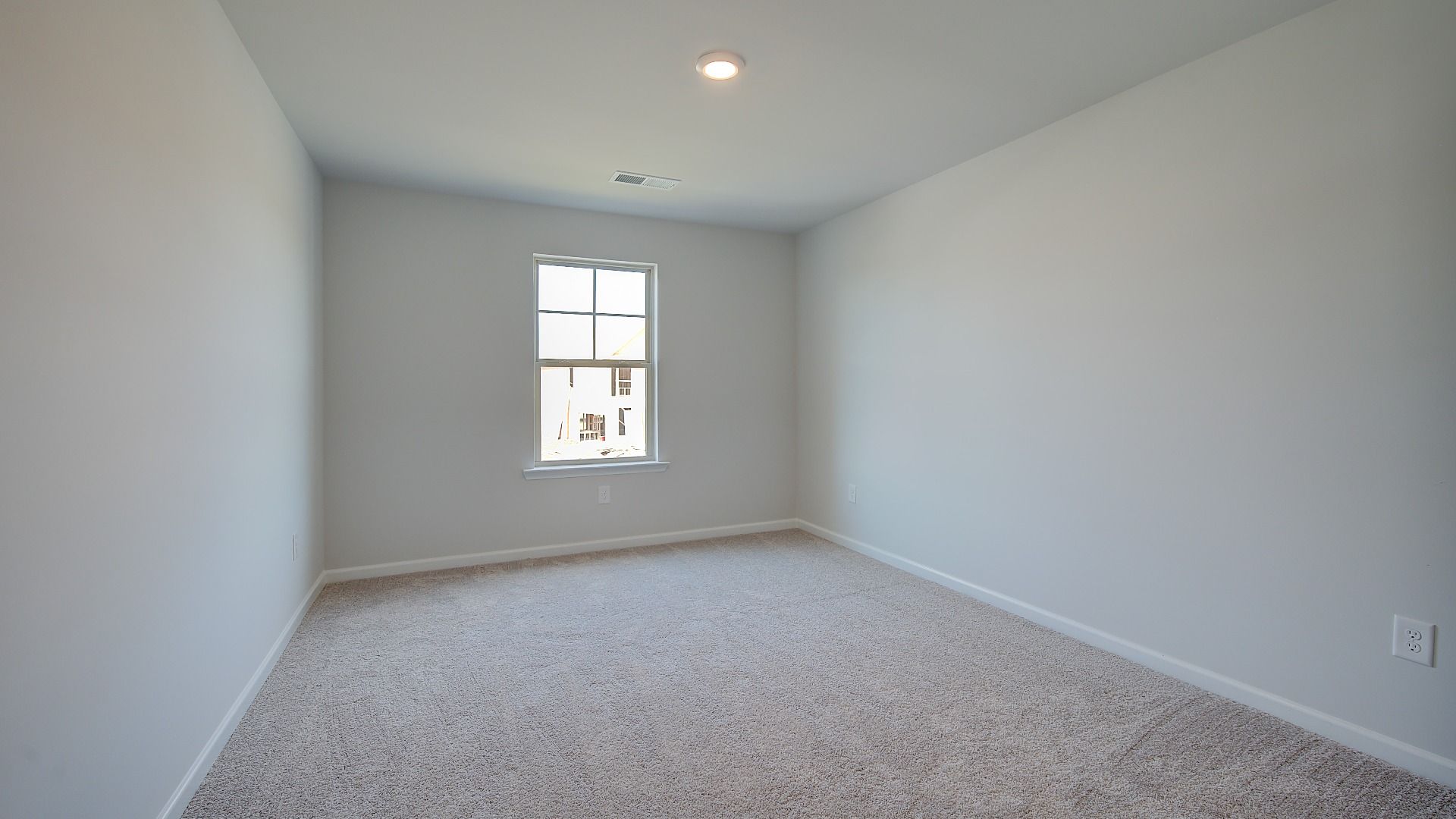 McKinley II spacious secondary bedroom with carpet flooring and natural light at Brighton in Locust Grove, GA.
