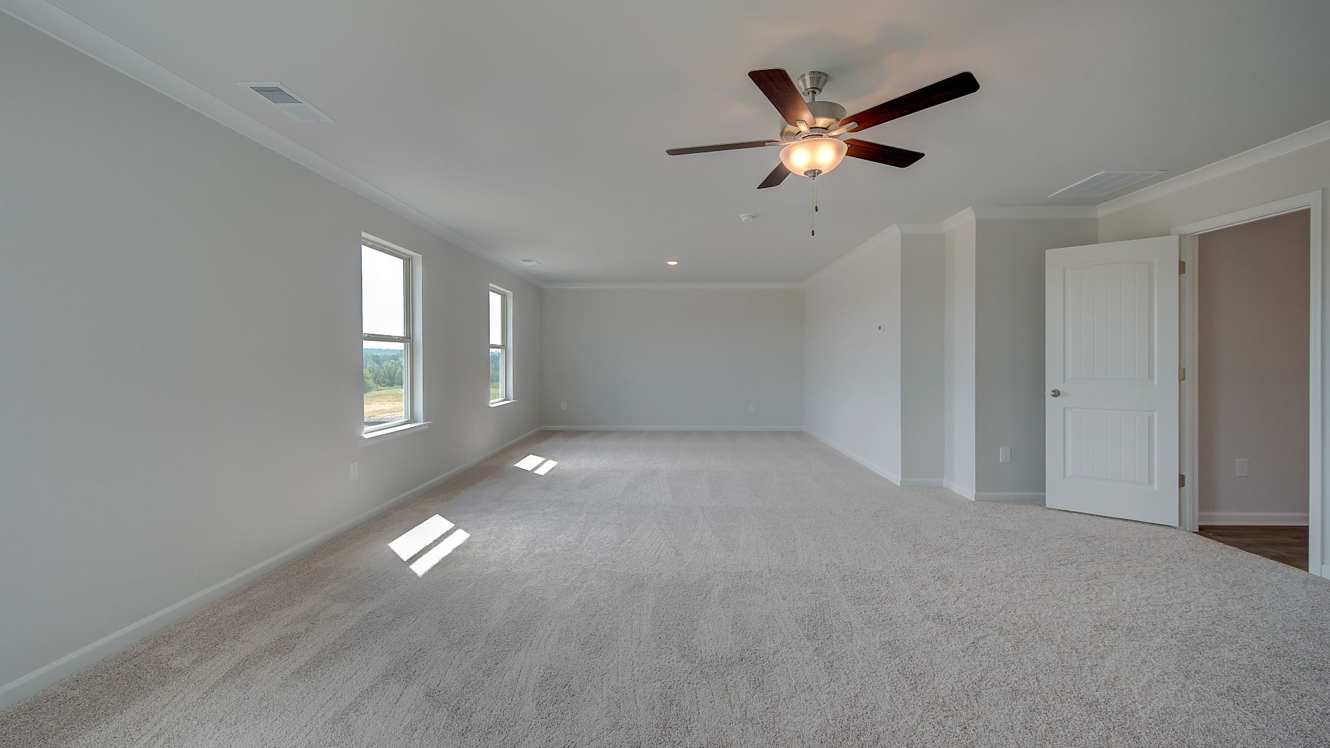 Primary suite sitting room for flexible use with tray ceiling and carpet flooring in the McKinley II at Brighton.