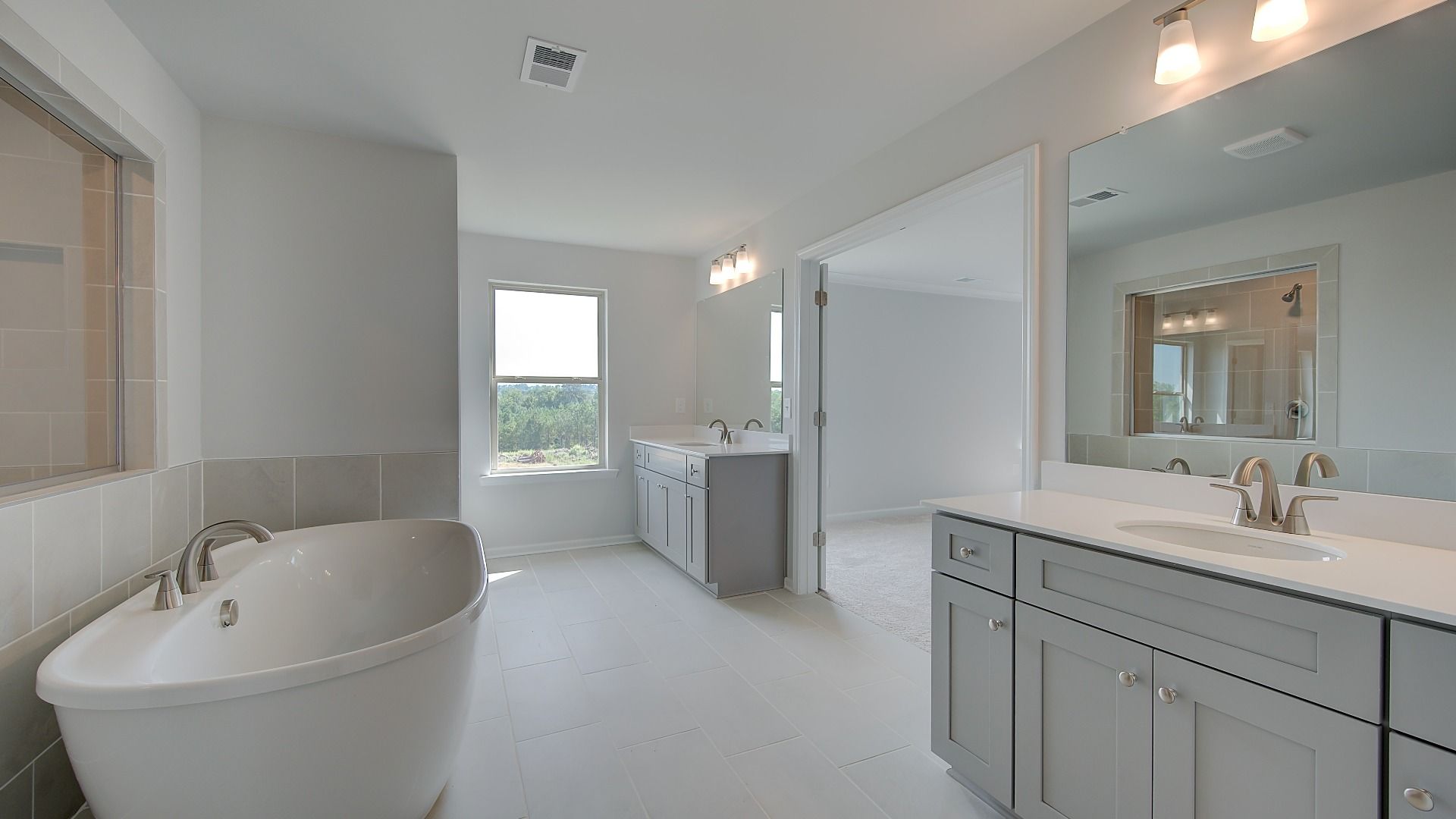 Modern primary bath with tile flooring and freestanding tub in the McKinley II at Brighton in Locust Grove, GA.