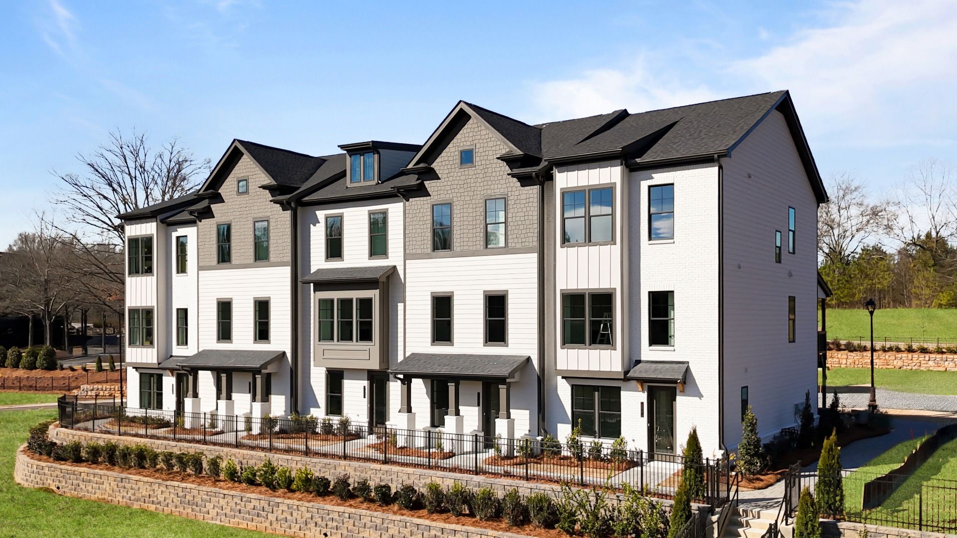 Three-story Barrett Pointe Seaton townhomes featuring contemporary design and landscaped grounds in Kennesaw, GA.