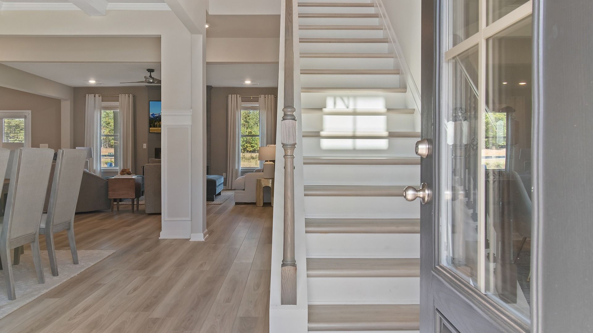 McKinley II entry featuring front door with glass panels opening to foyer with LVP flooring at Brighton in Locust Grove, GA.