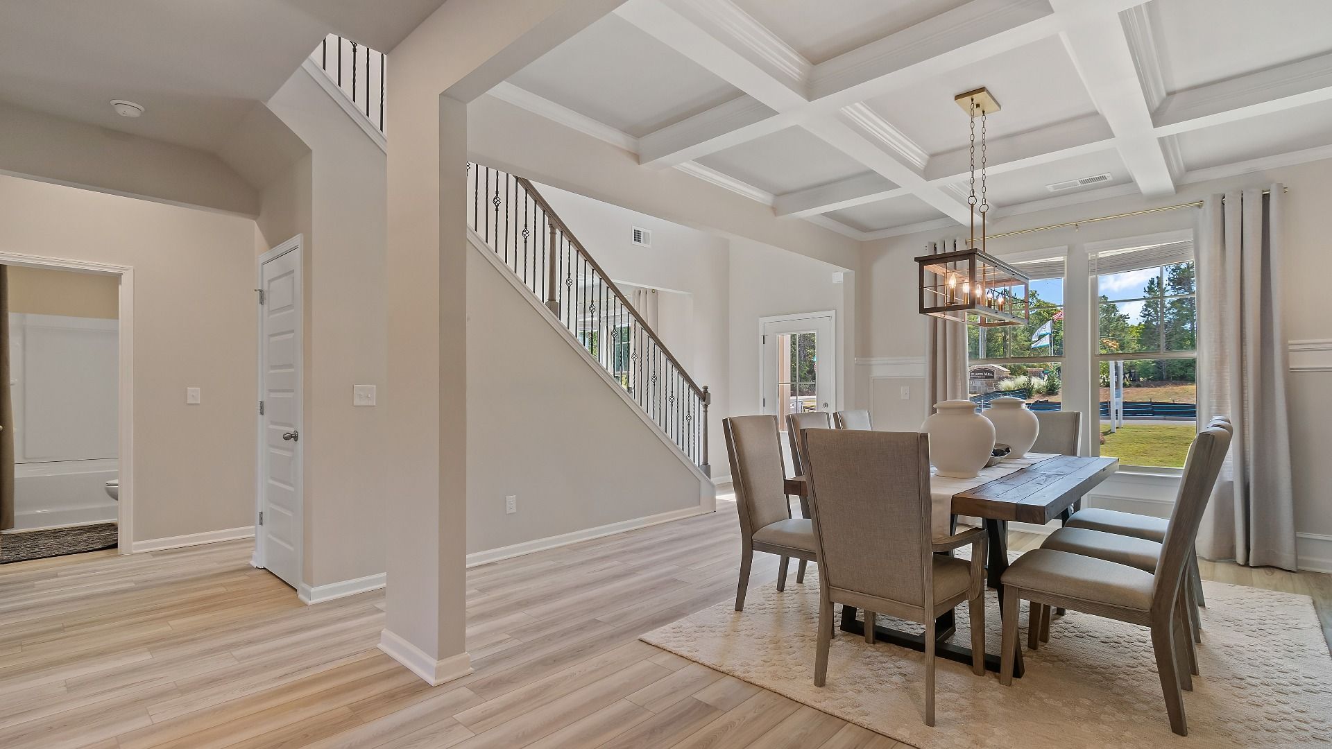 Open dining room with coffered ceiling, spacious seating, and neutral modern finishes in the McKinley II at Brighton.