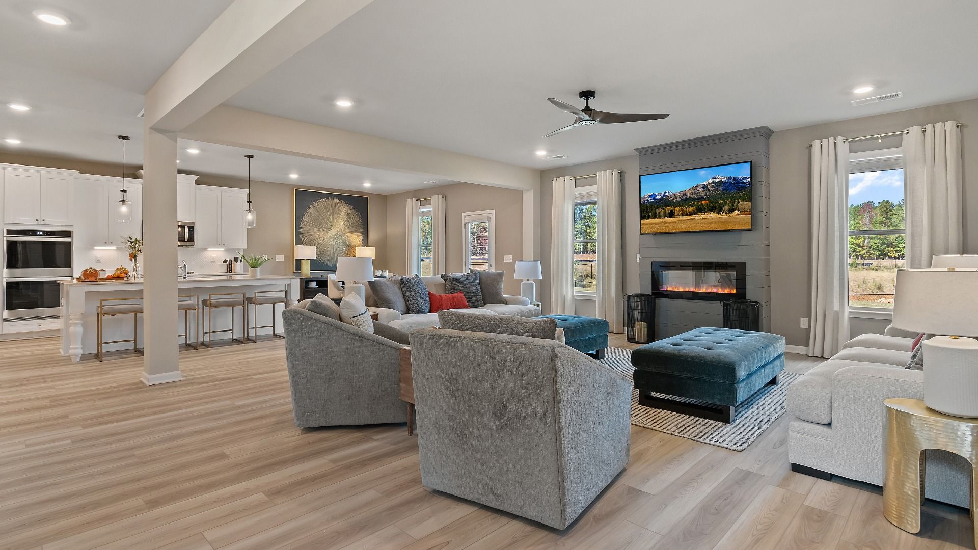 Open-concept family room with electric fireplace, abundant seating area, and LVP flooring in the McKinley II at Brighton.