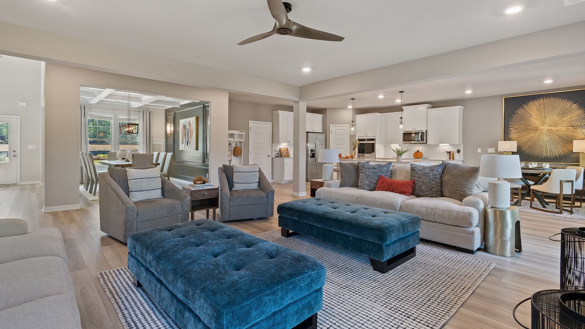 McKinley II open-concept family room with ceiling fan lighting and LVP flooring at Brighton in Locust Grove, GA.