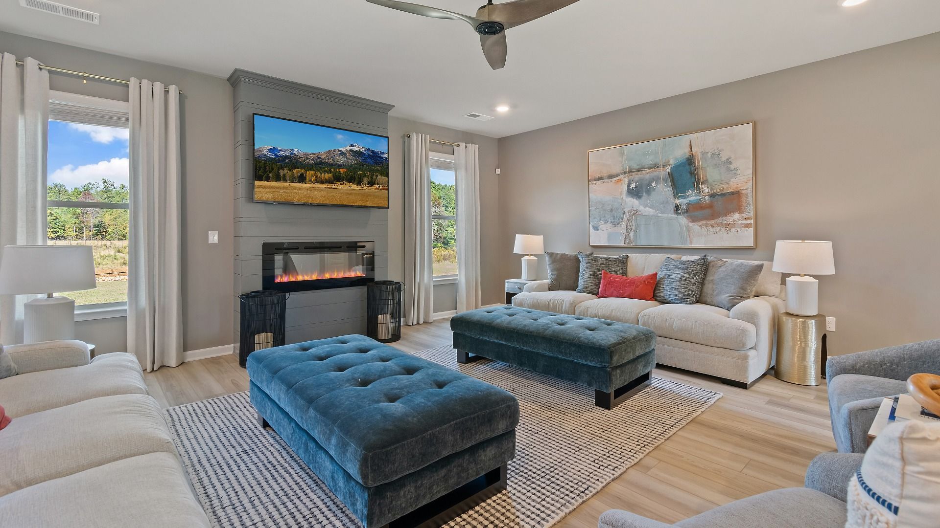 McKinley II family room with natural light, electric fireplace, and LVP flooring at Brighton in Locust Grove, GA.