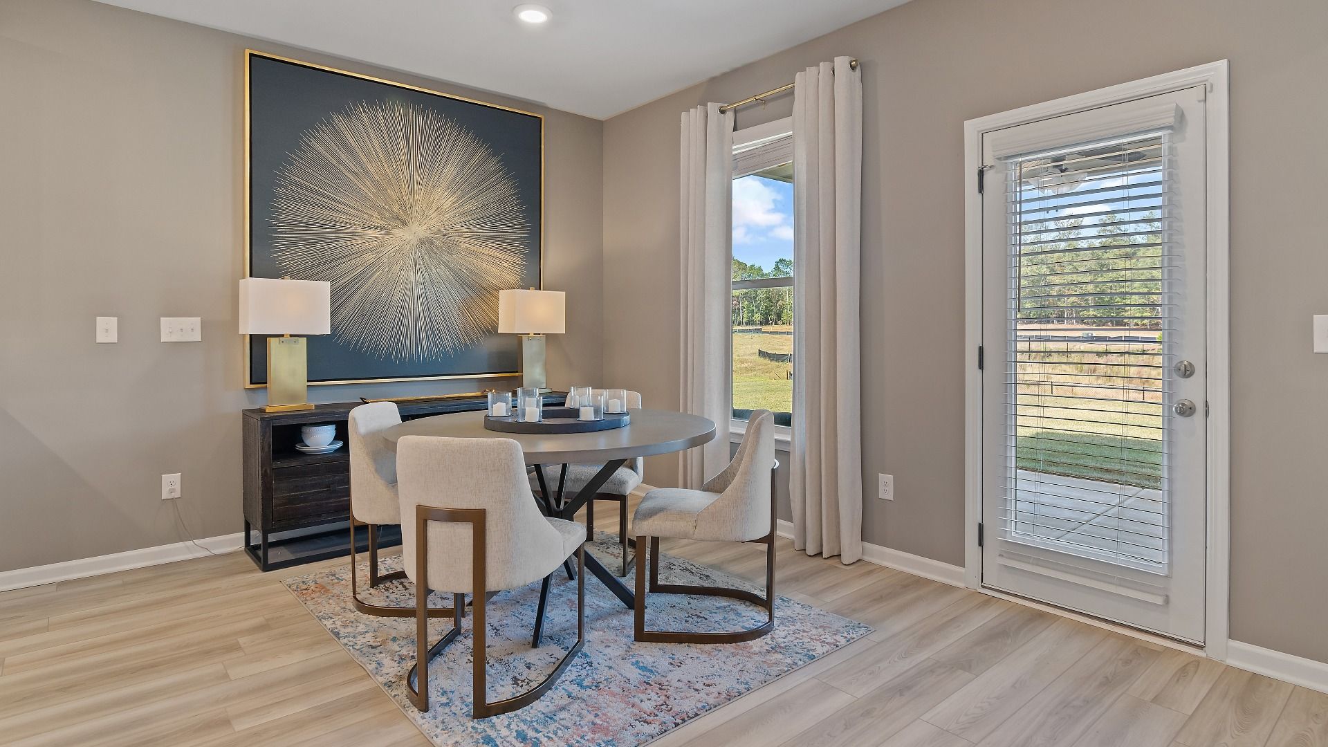 McKinley II open breakfast area with LVP flooring and view of backyard at Brighton in Locust Grove, GA.