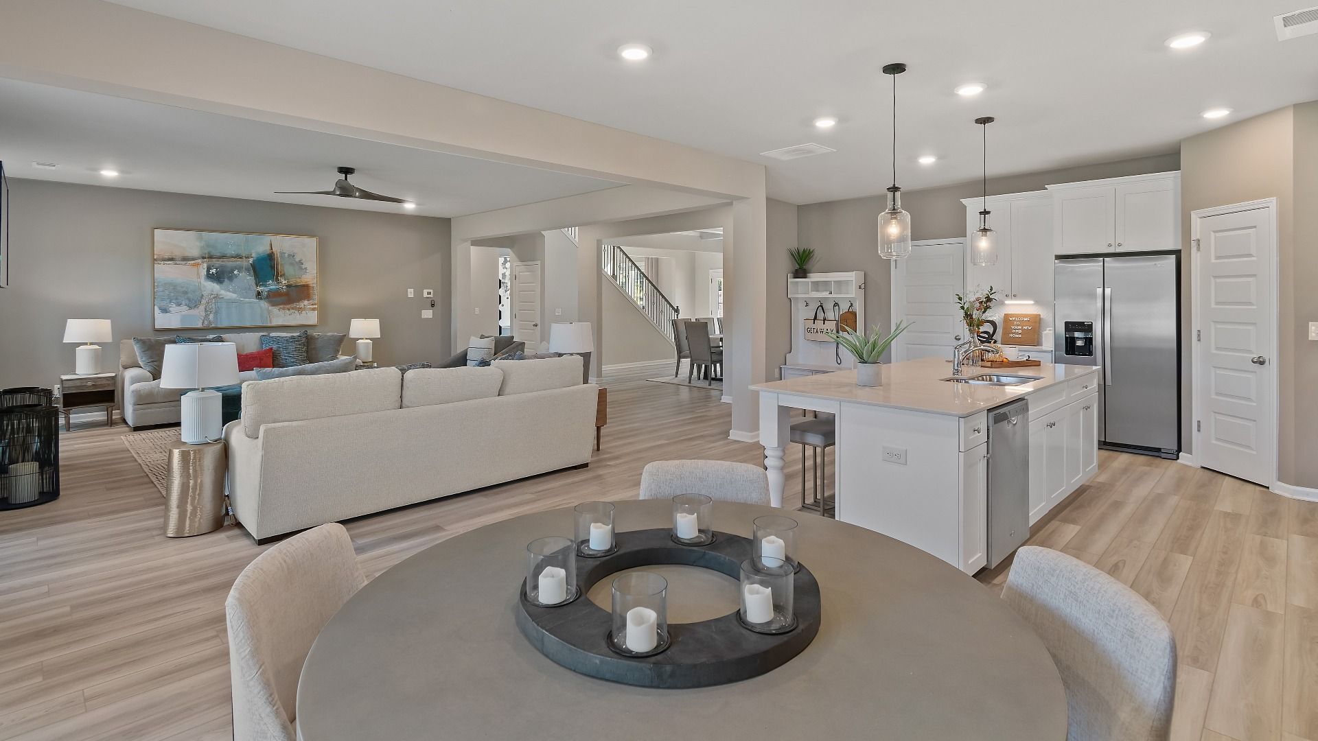 Open-concept first floor with breakfast area, kitchen, and family room featuring LVP flooring in the McKinley II at Brighton.