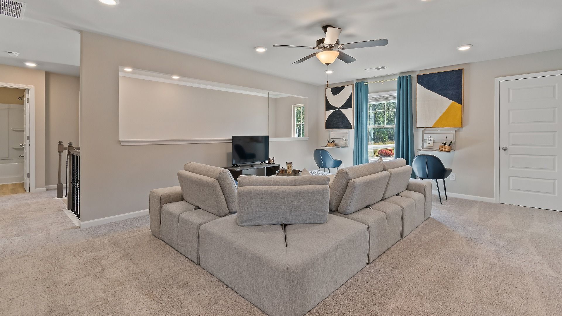 McKinley II spacious loft with carpet flooring, natural light, and ceiling fan light at Brighton in Locust Grove, GA.