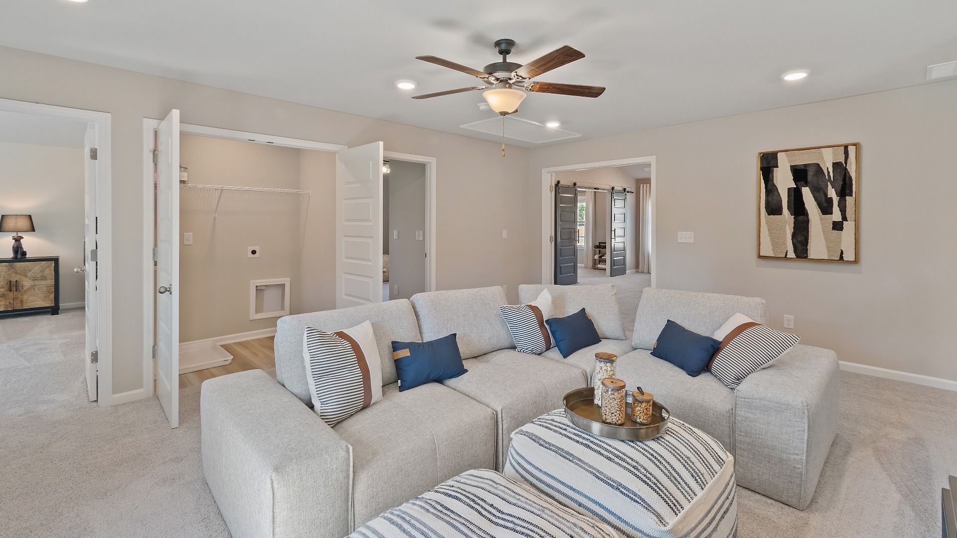 McKinley II spacious loft with carpet flooring, natural light, and ceiling fan light at Brighton in Locust Grove, GA.
