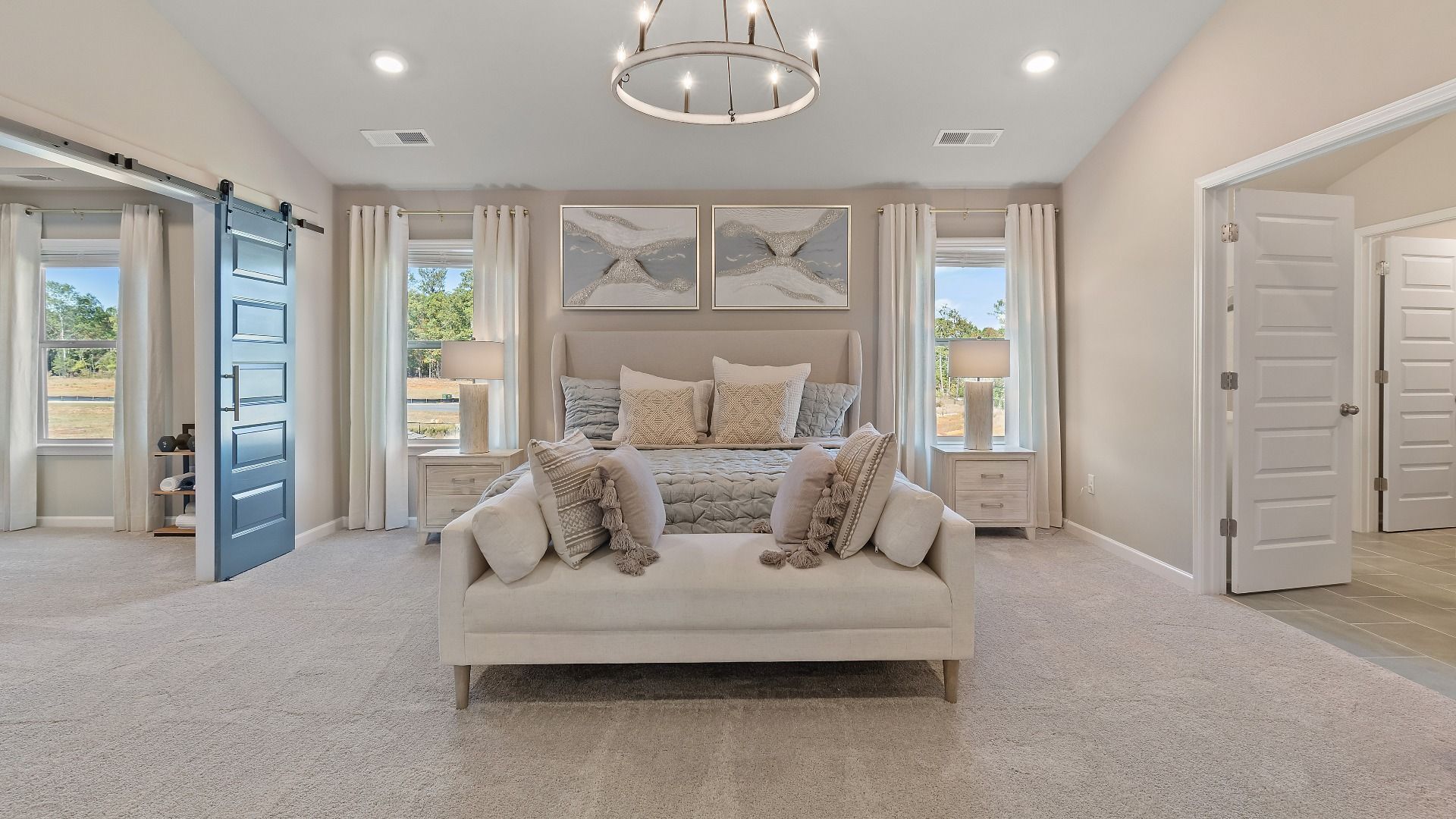 McKinley II expansive primary suite with carpet flooring, natural light, and sitting area at Brighton in Locust Grove, GA.