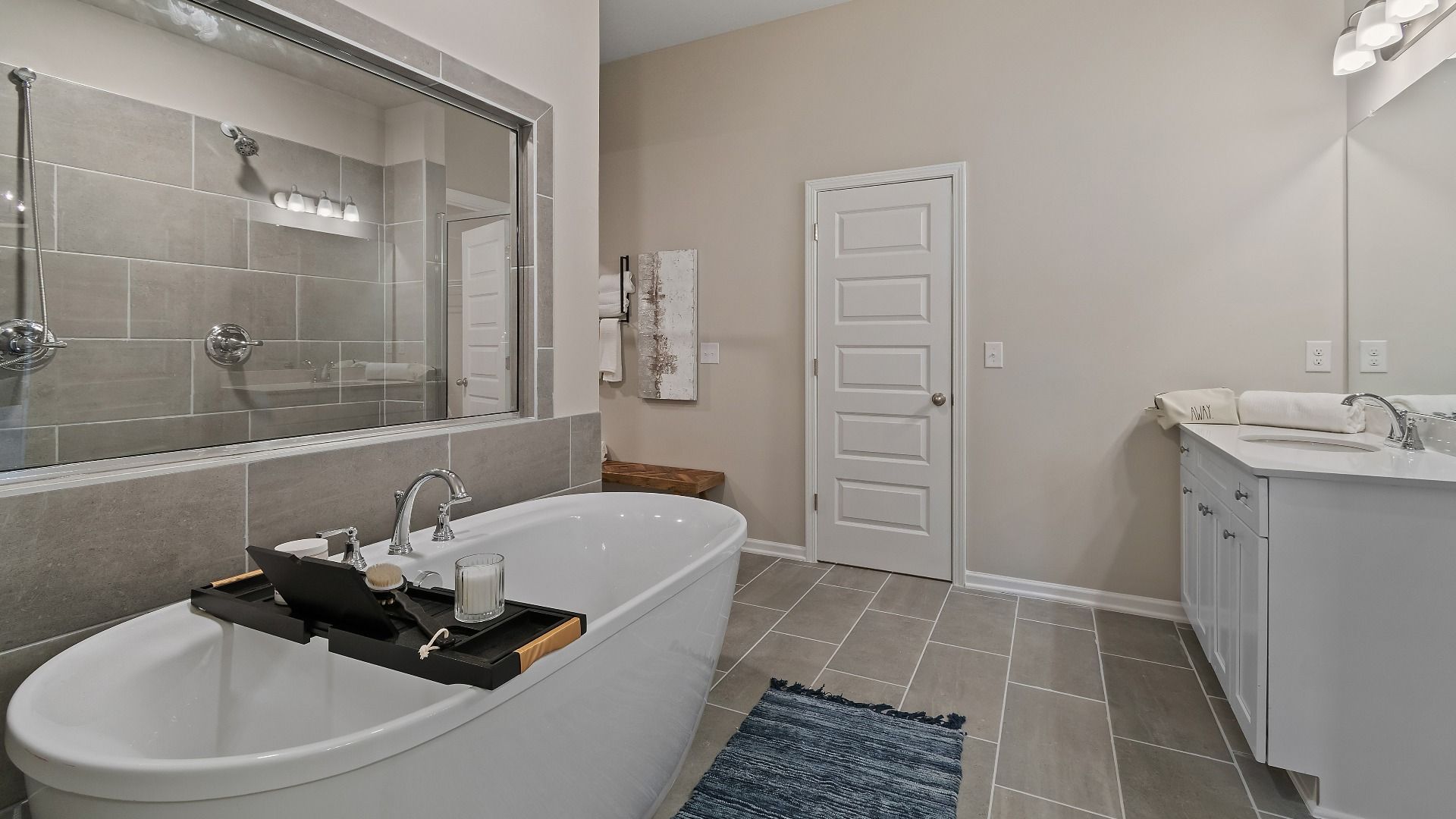 Modern primary bath with tile flooring and freestanding tub in the McKinley II at Brighton in Locust Grove, GA.