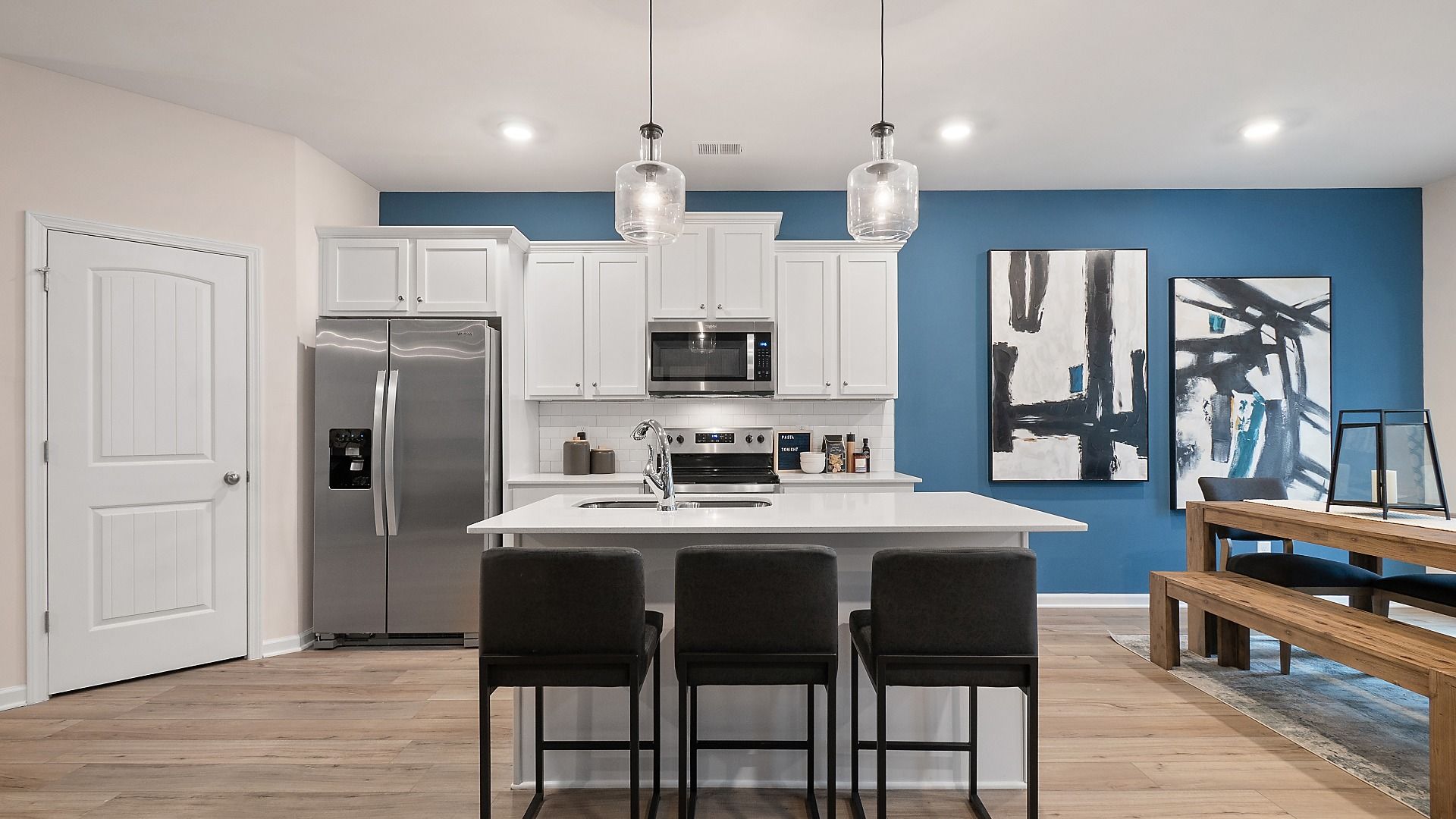 Zoey II kitchen featuring pendant lighting, white cabinetry, and center island with seating at Abbotts Crossing.