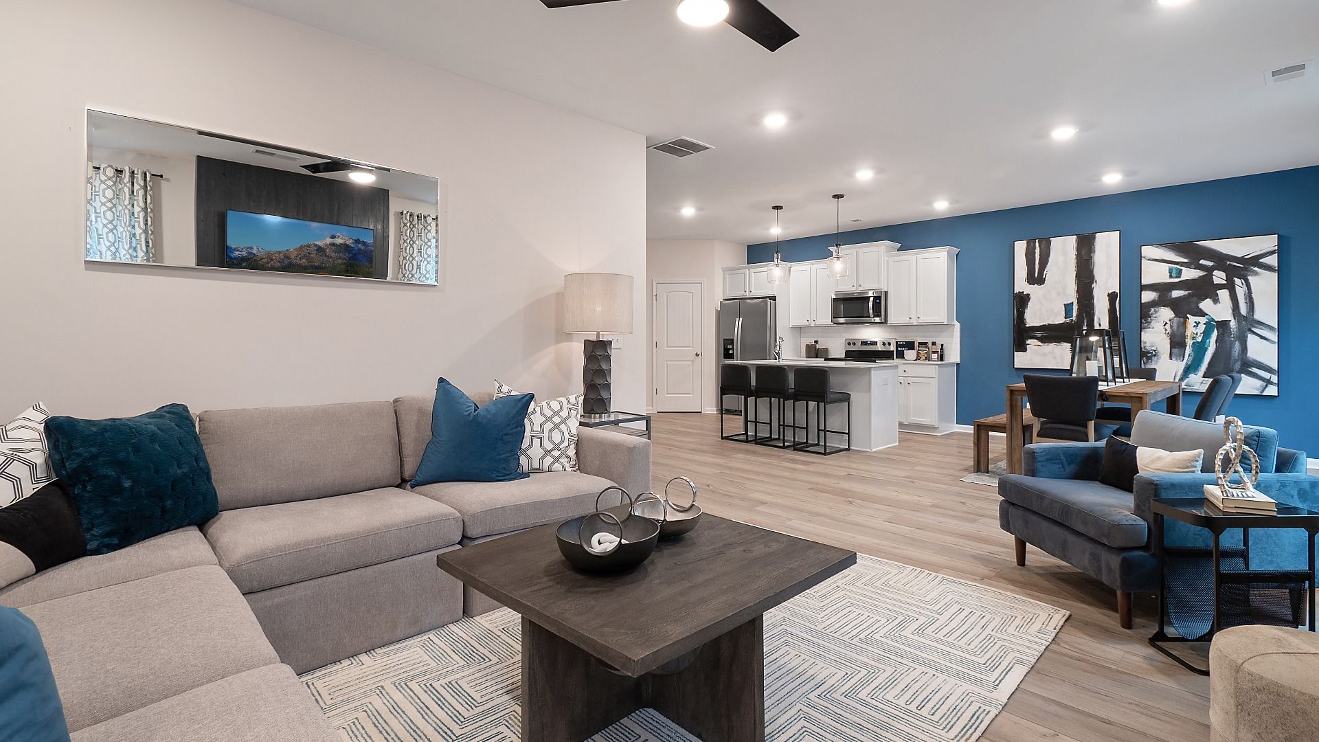 Zoey II spacious family room with LVP flooring and view to kitchen and breakfast area at Abbotts Crossing.