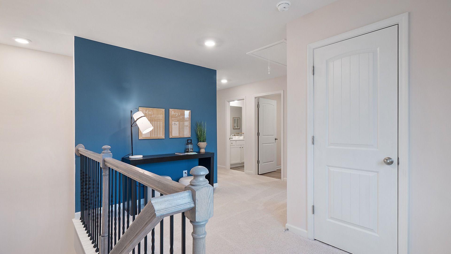 Zoey II upstairs landing with carpet flooring and open hallway into second floor at Abbotts Crossing in Conyers, GA.