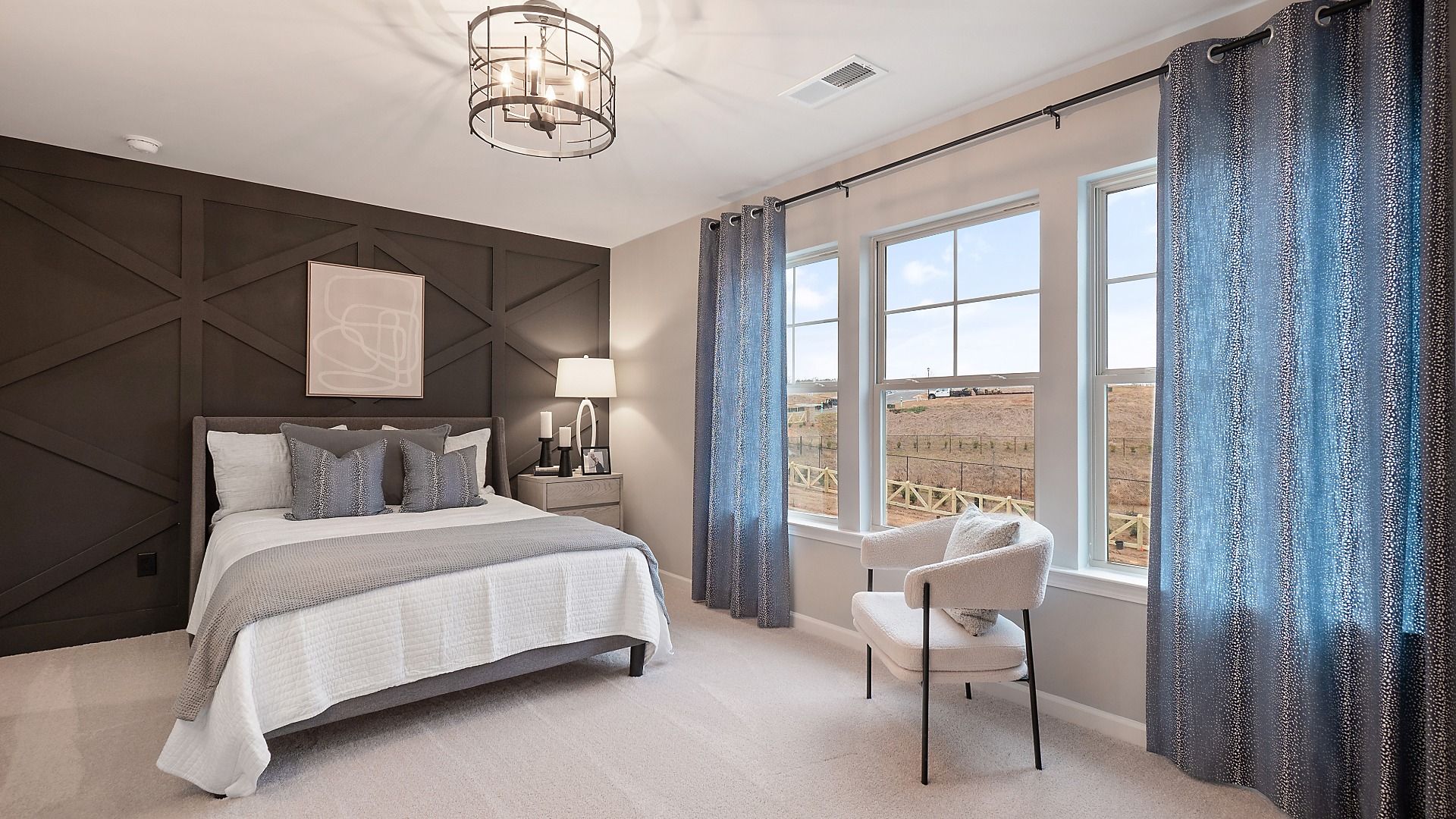 Zoey II secondary bedroom with carpet flooring, abundant natural light, and neutral modern details at Abbotts Crossing.