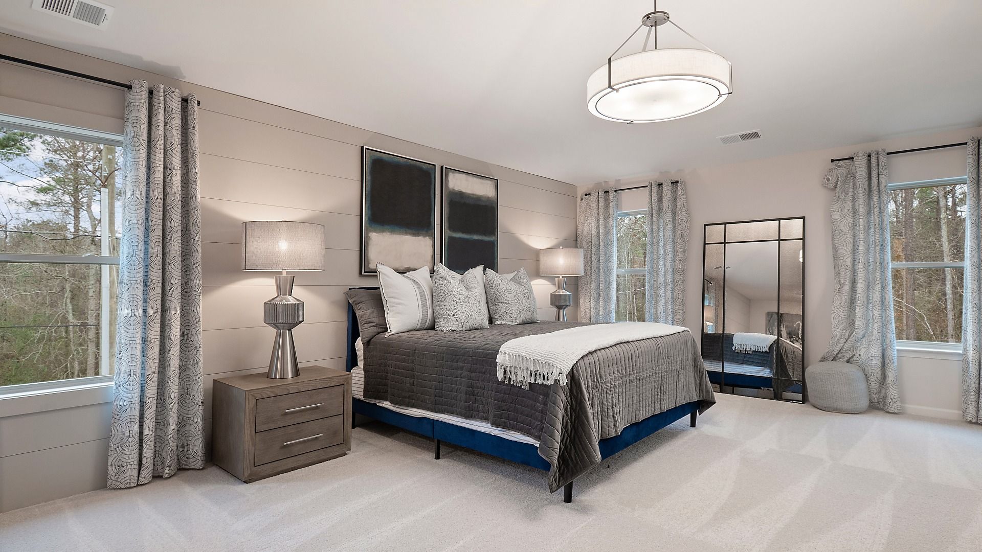 Primary suite with neutral modern finishes, natural light, and carpet flooring in the Zoey II plan at Abbotts Crossing.