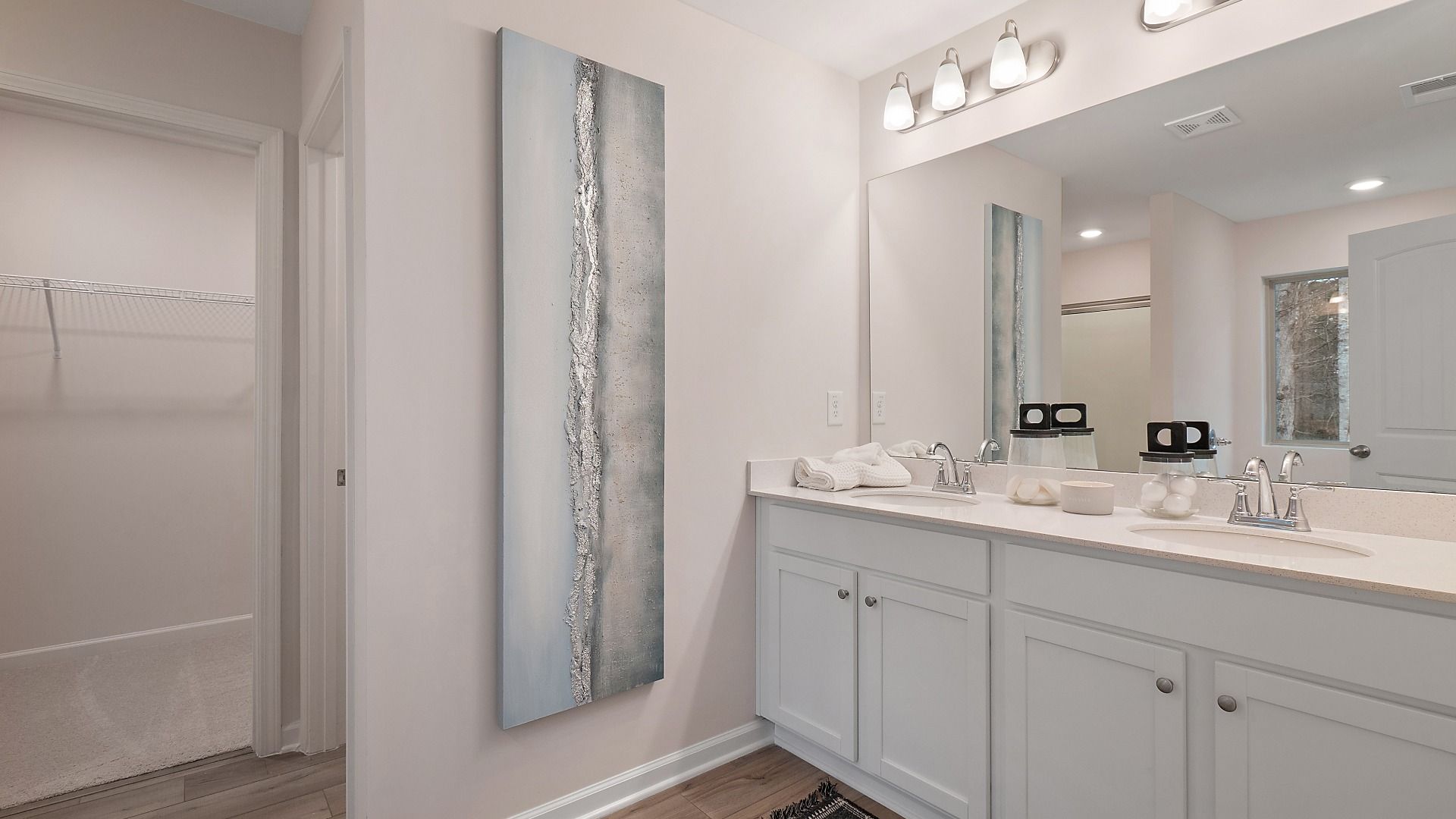 Bright primary bath with LVP flooring and dual vanities in the Zoey II plan at Abbotts Crossing.