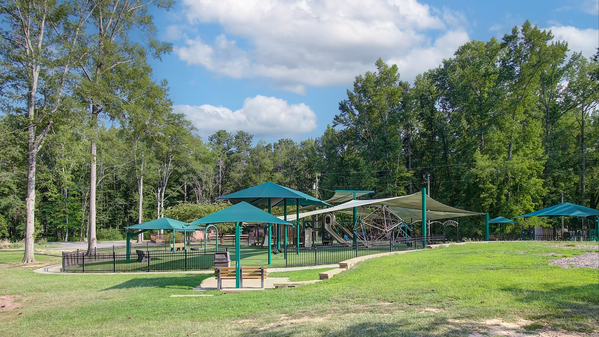 Community playground with a variety of slides, swings, and climbing structures near Saddleridge in Senoia, GA.