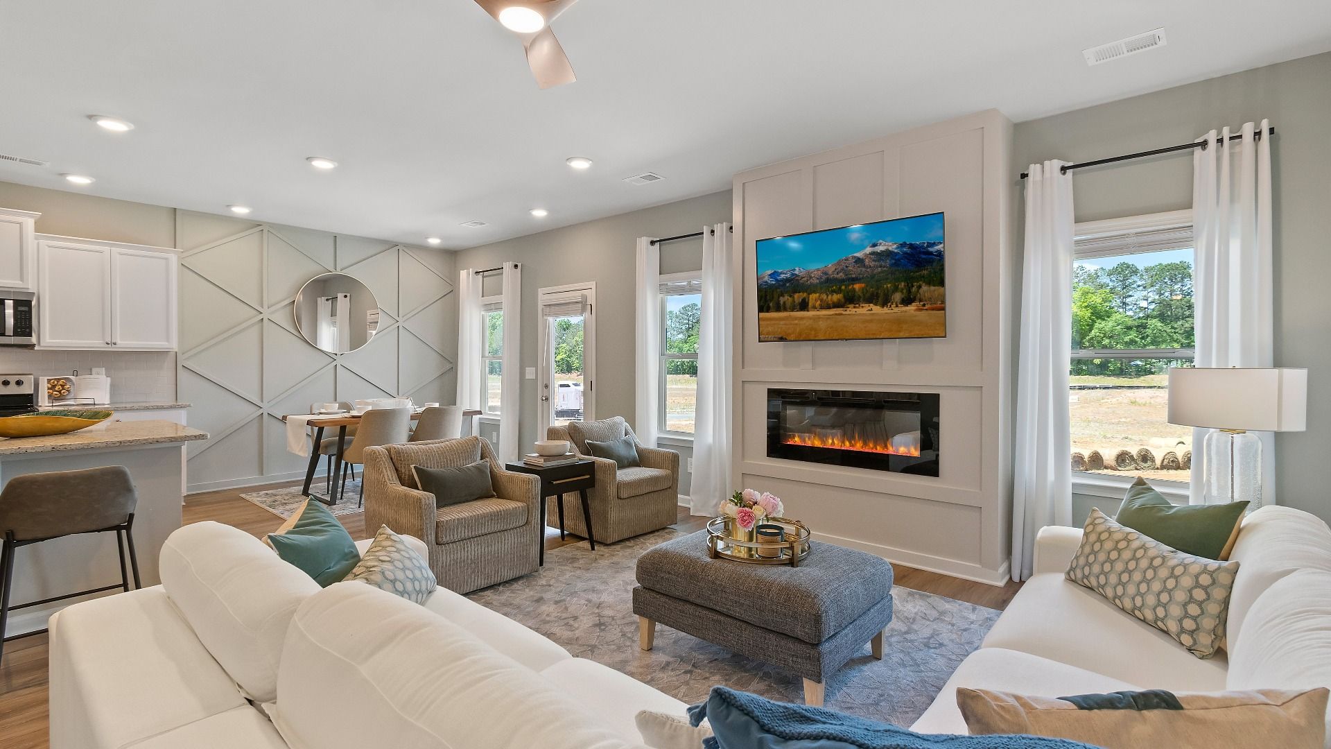 Expansive family room with center electric fireplace, natural light, and LVP flooring in the Everest III at Berkeley Lakes.