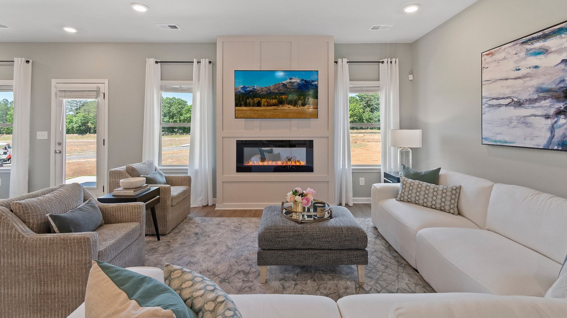 Expansive family room with center electric fireplace, natural light, and LVP flooring in the Everest III at Berkeley Lakes.