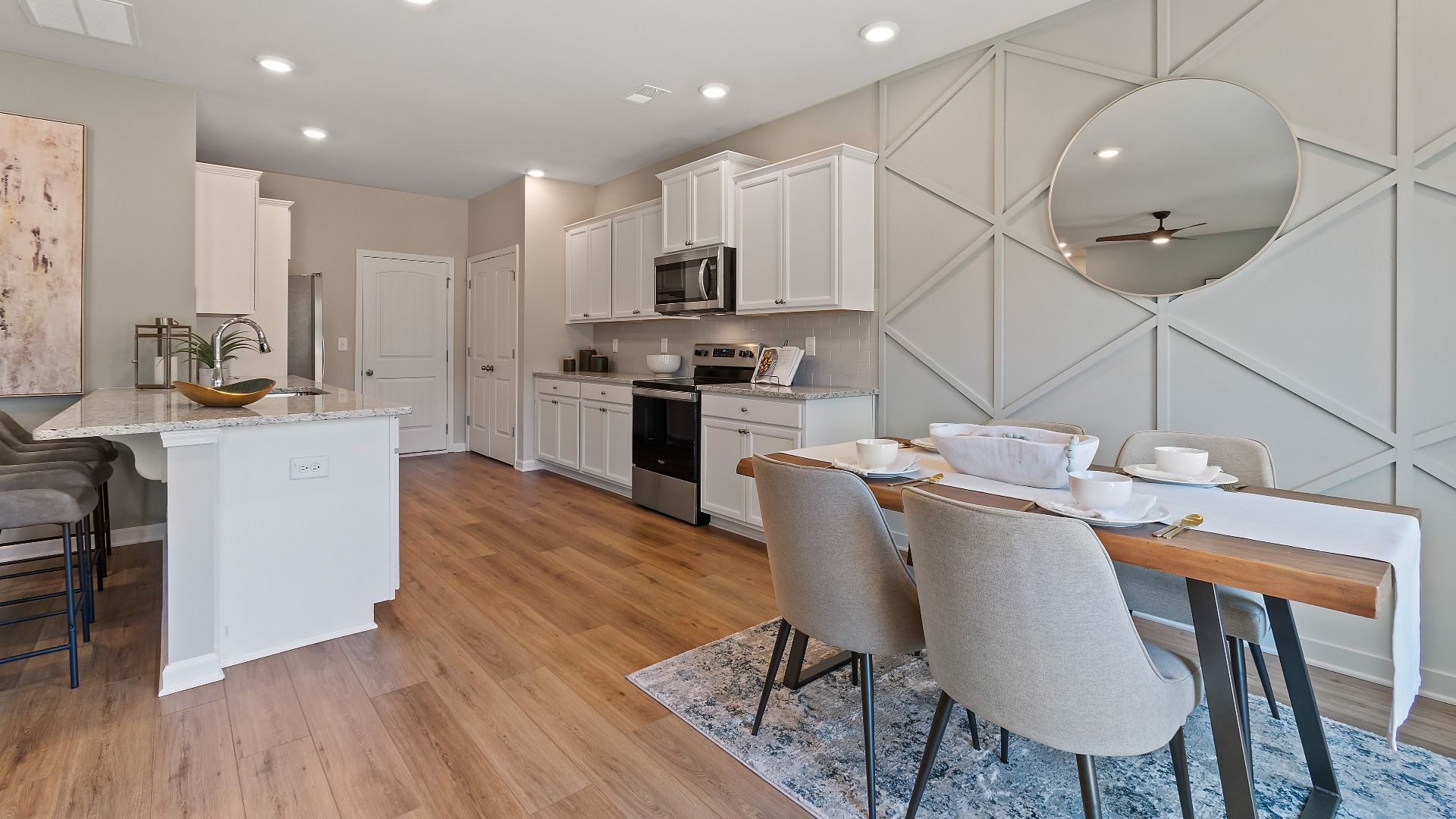 Everest III open kitchen and breakfast area with LVP flooring and modern neutral finishes at Berkeley Lakes.
