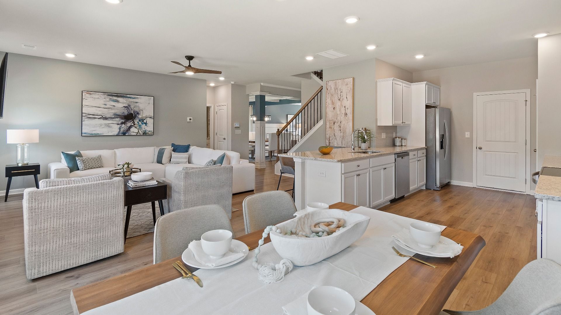 Bright open-concept first floor with LVP flooring and modern neutral interior design in the Everest III at Berkeley Lakes.
