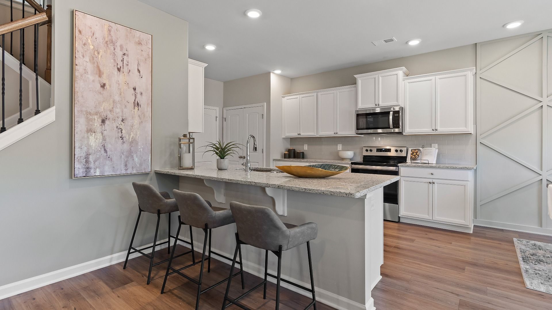 Everest III kitchen with LVP flooring, counter seating, and white tile backsplash and cabinetry at Berkeley Lakes.