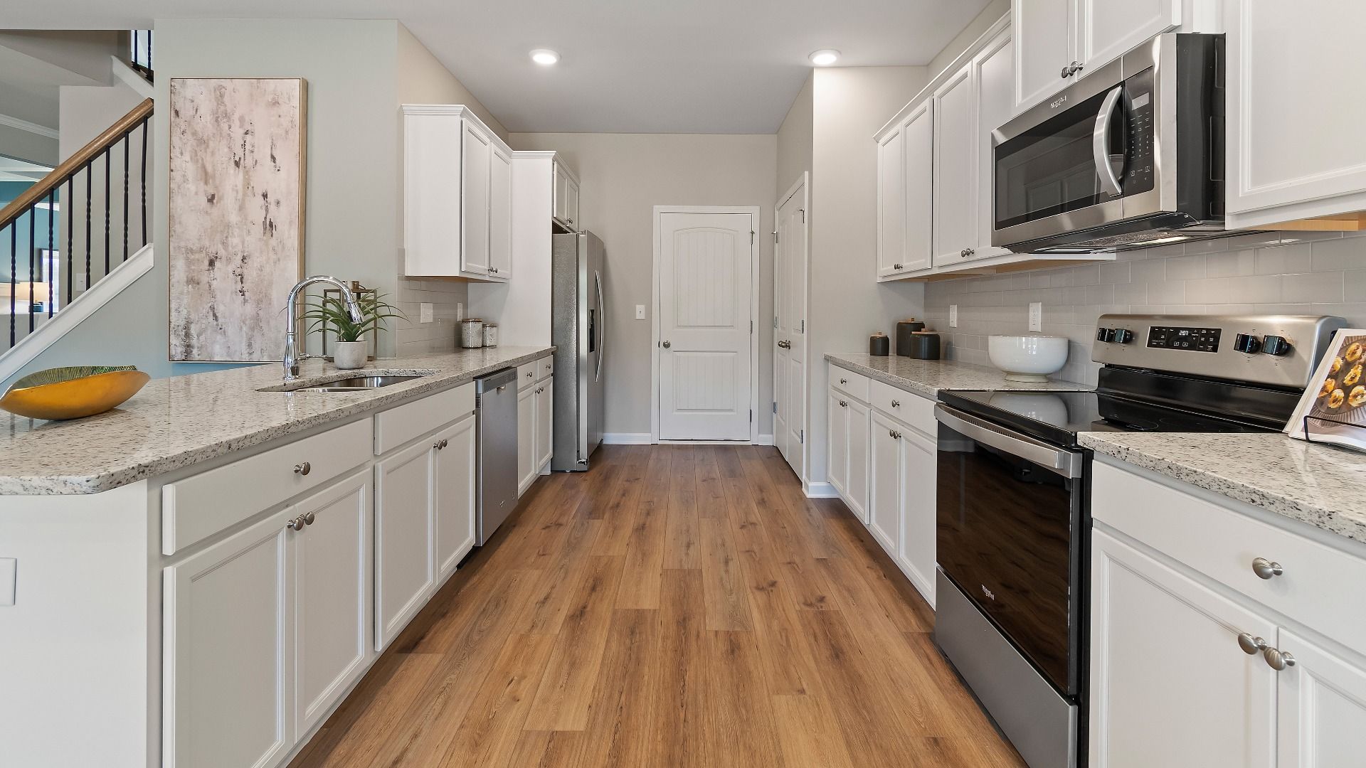 Everest III kitchen with white cabinetry, granite countertops, and stainless appliances at Berkeley Lakes in Locust Grove, GA