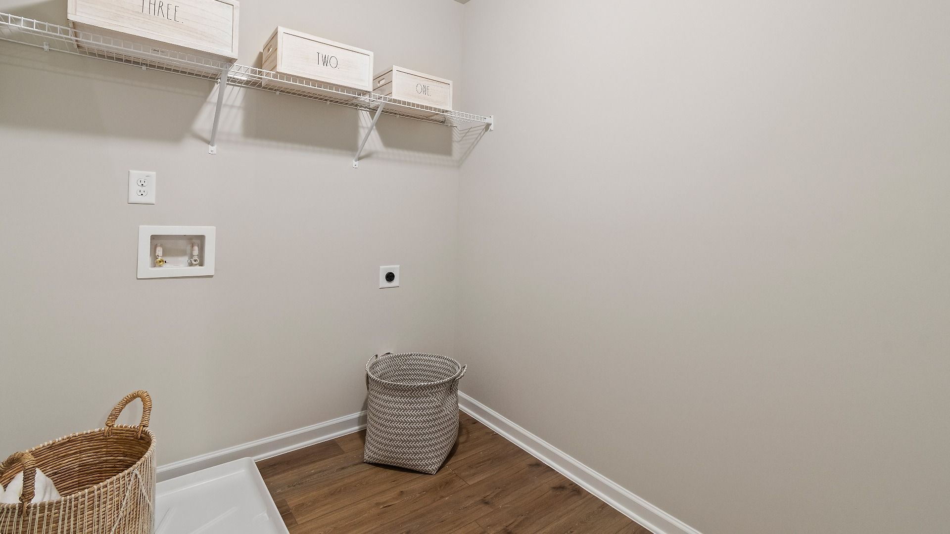 Everest III laundry with LVP flooring and built-in shelving at Berkeley Lakes in Locust Grove, GA.