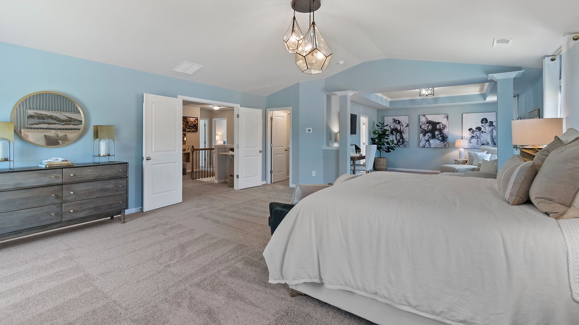 Expansive primary suite with carpet flooring, double door entry, and room for seating in the Everest III at Berkeley Lakes.