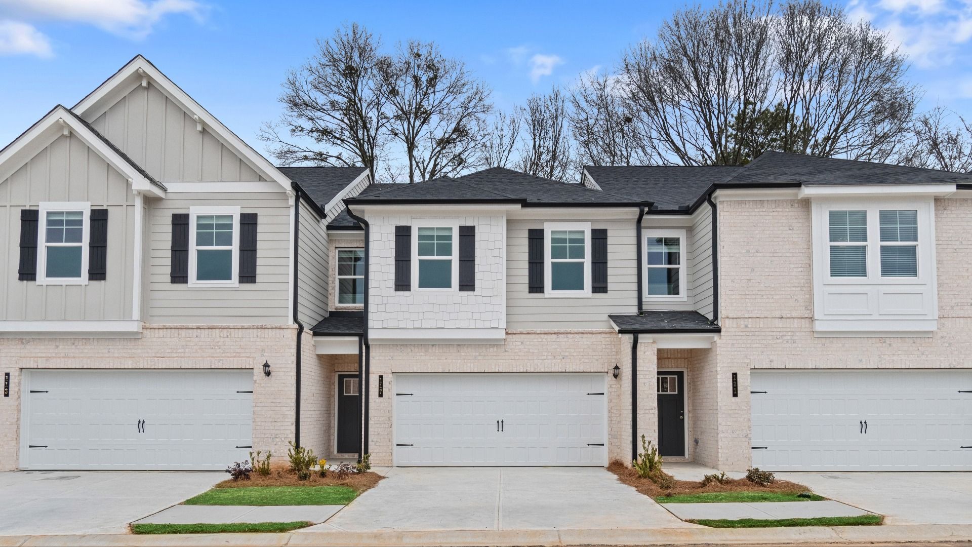 Dallas two-story townhome exterior in Stockbridge, GA with brick accents, modern siding, gabled roof, and covered entry.