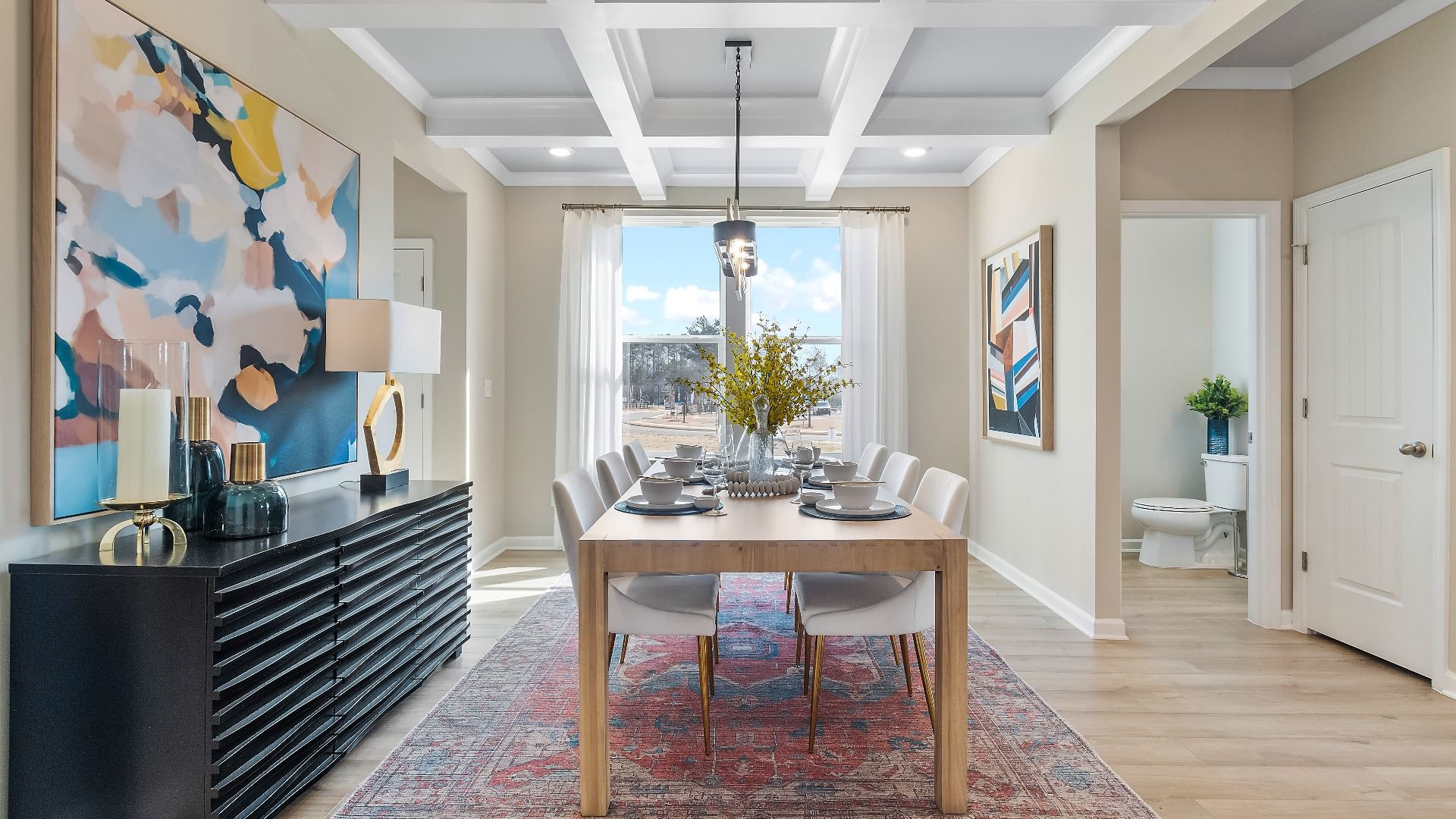 Bright, spacious dining room with coffered ceiling and large window at Cooper Park in McDonough, GA.