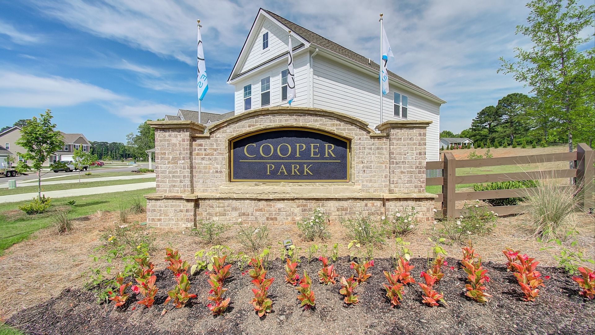 Welcoming brick entrance monument to Cooper Park new single-family home community with manicured landscaping.