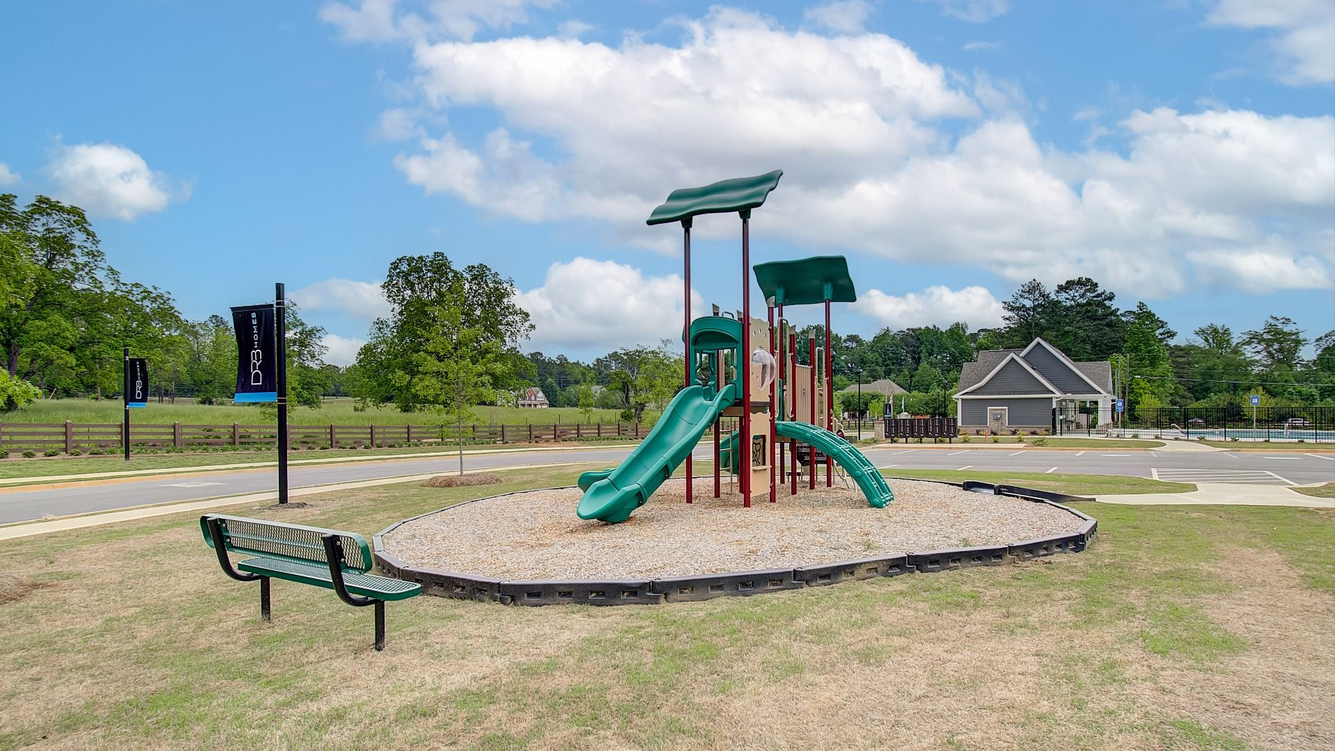 Outdoor playground amenity with bench at Cooper Park in McDonough, GA.