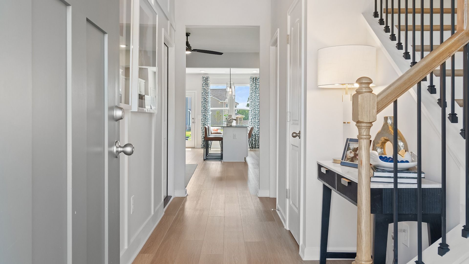 Entry into the Millhaven home with modern gray door, showing stairs and LVP flooring through the first level in Conyers, GA.