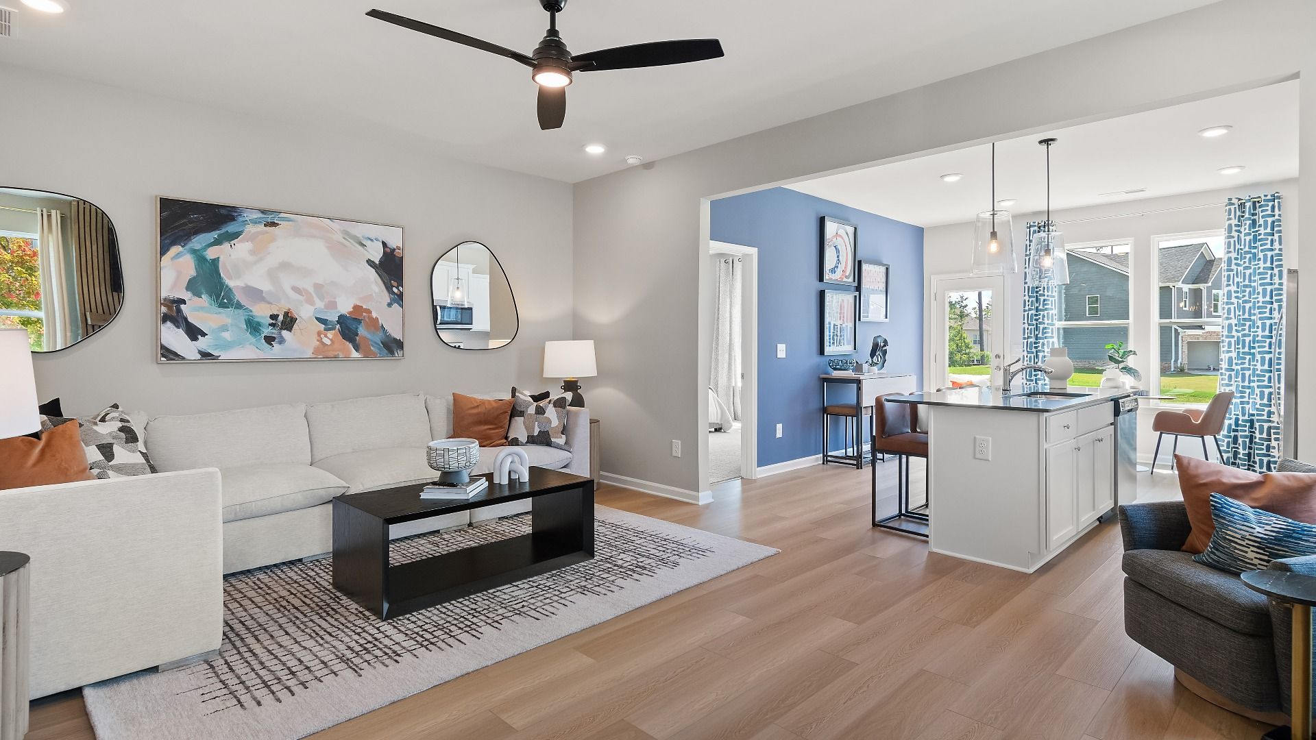 Millhaven family room with neutral finishes, LVP flooring, and open layout flowing into the kitchen at Abbotts Crossing.