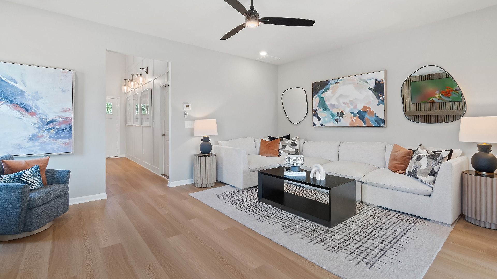 Spacious family room with LVP flooring and neutral color palette at Abbotts Crossing in Conyers, GA