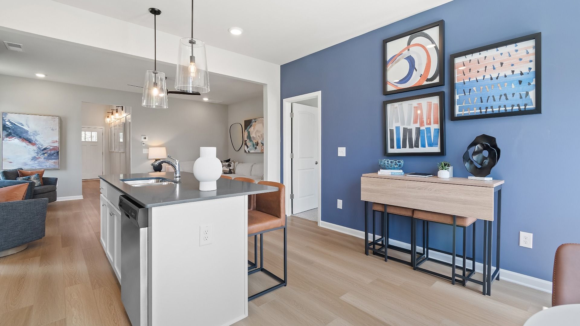Millhaven kitchen featuring center island with seating and view into family room at Abbotts Crossing in Conyers, GA.
