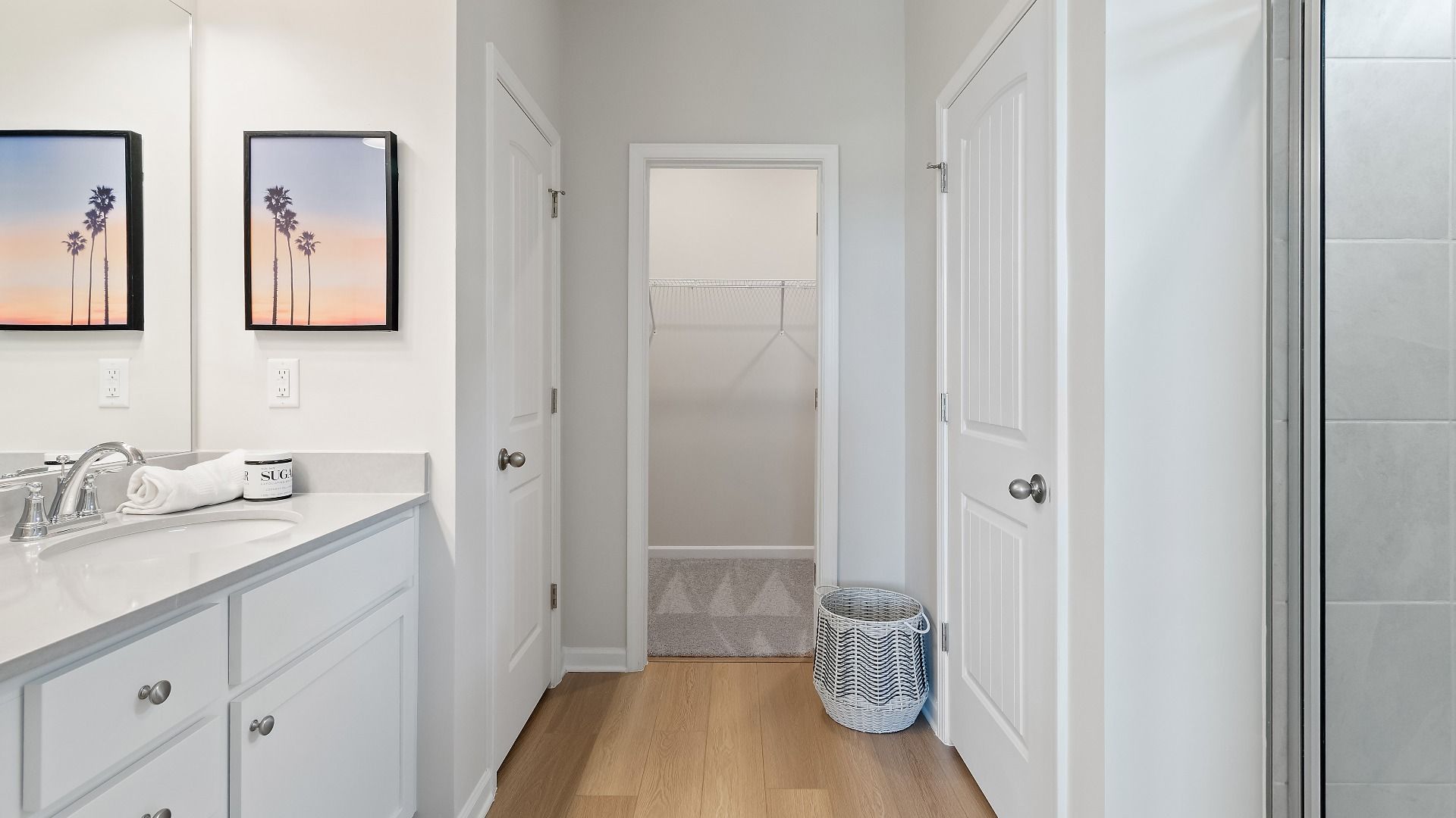 Primary bath in Millhaven floorplan featuring connecting walk-in closet and LVP flooring at Abbotts Crossing in Conyers, GA.