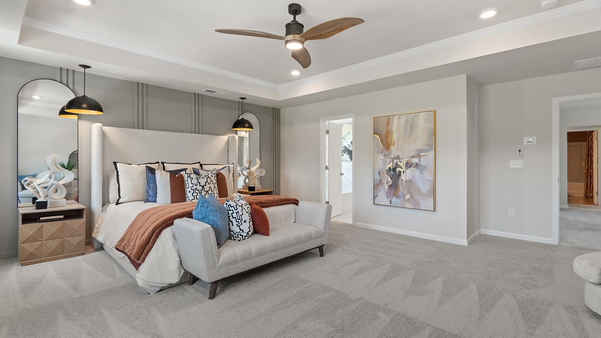 Primary suite on second floor in Millhaven plan with carpet flooring and tray ceiling at Abbotts Crossing in Conyers, GA.