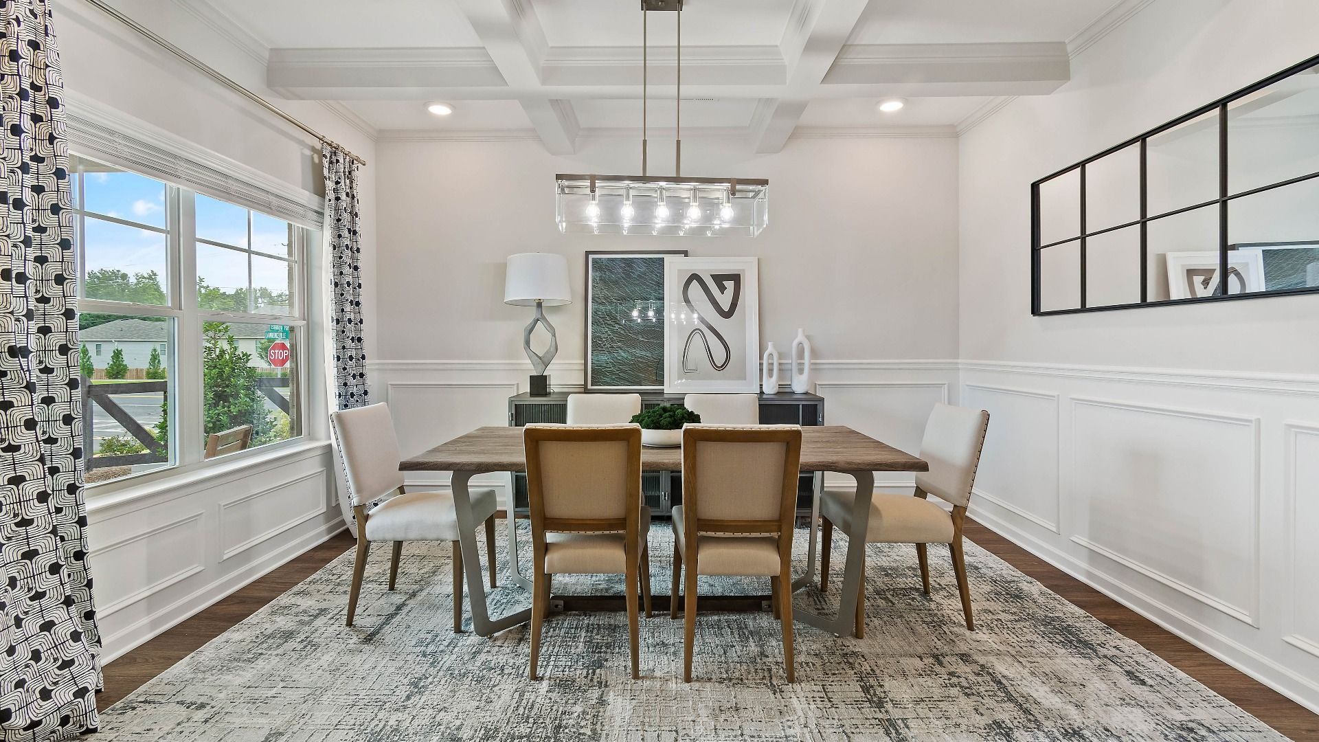 Naturally lit dining room with coffered ceiling and large windows in the Isabella II at Adagio in Dacula, GA.