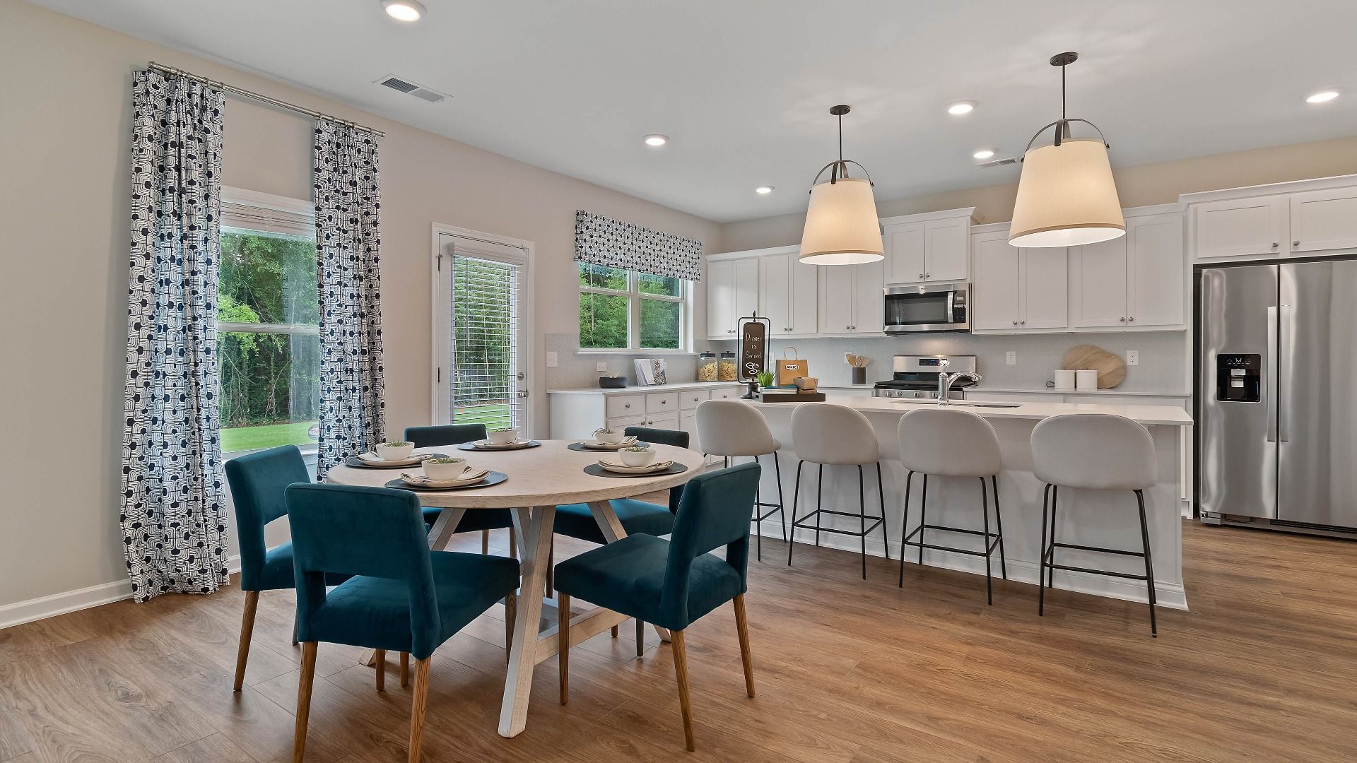 Open breakfast area with natural light and views into the kitchen and outdoor porch in Isabella II at Adagio in Dacula, GA.