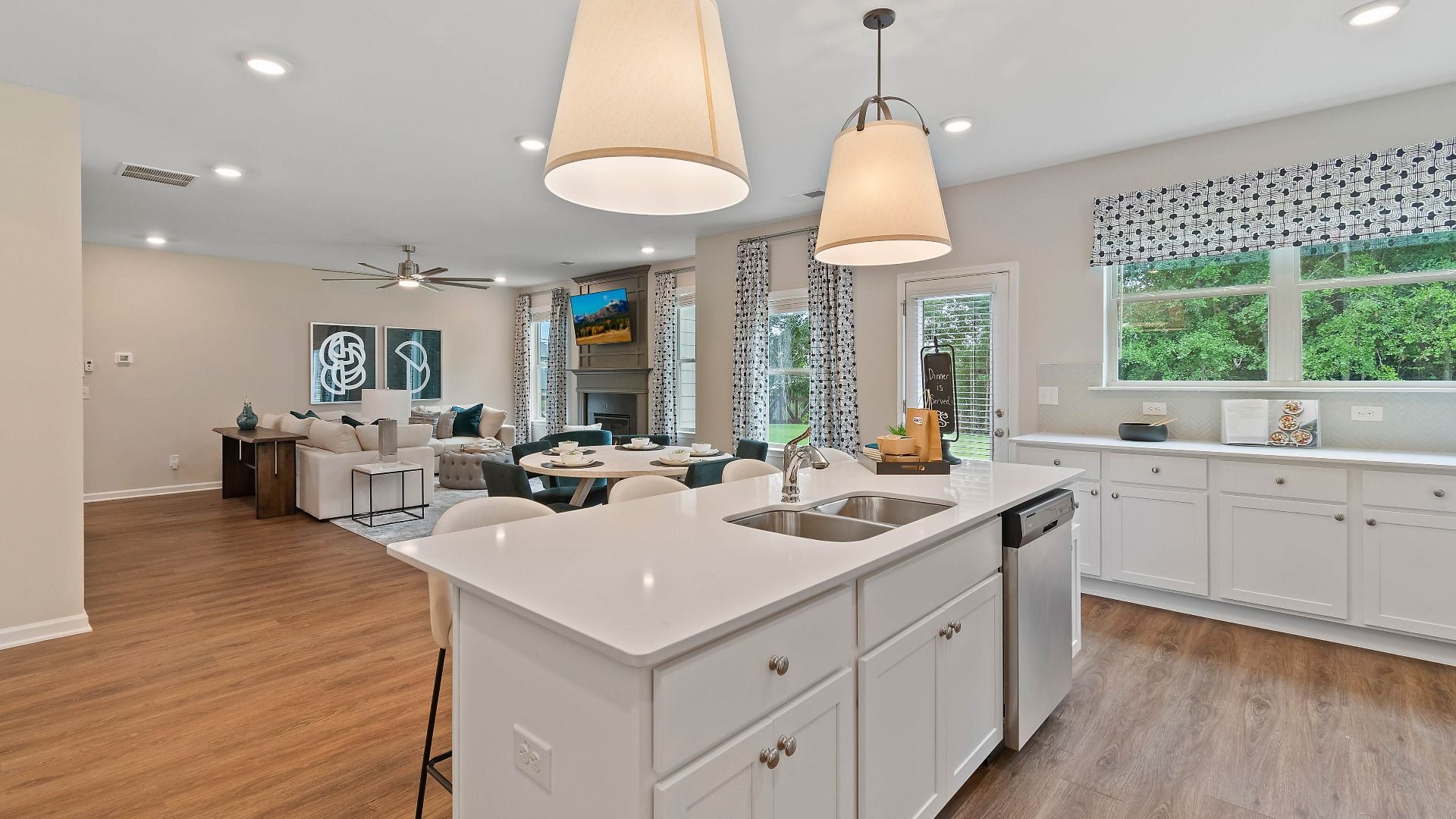 Bright kitchen with center island, modern white finishes, and views into the breakfast area in the Isabella II at Adagio.