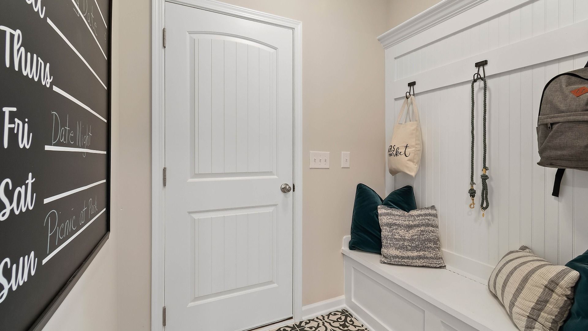 Mudroom with built-in bench and neutral finishes in the Isabella II at Adagio in Dacula, GA.