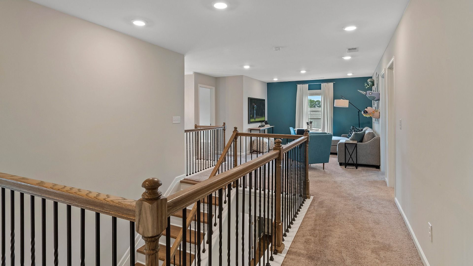 Upstairs landing with carpet flooring and a generous loft area in the Isabella II at Adagio in Dacula, GA.
