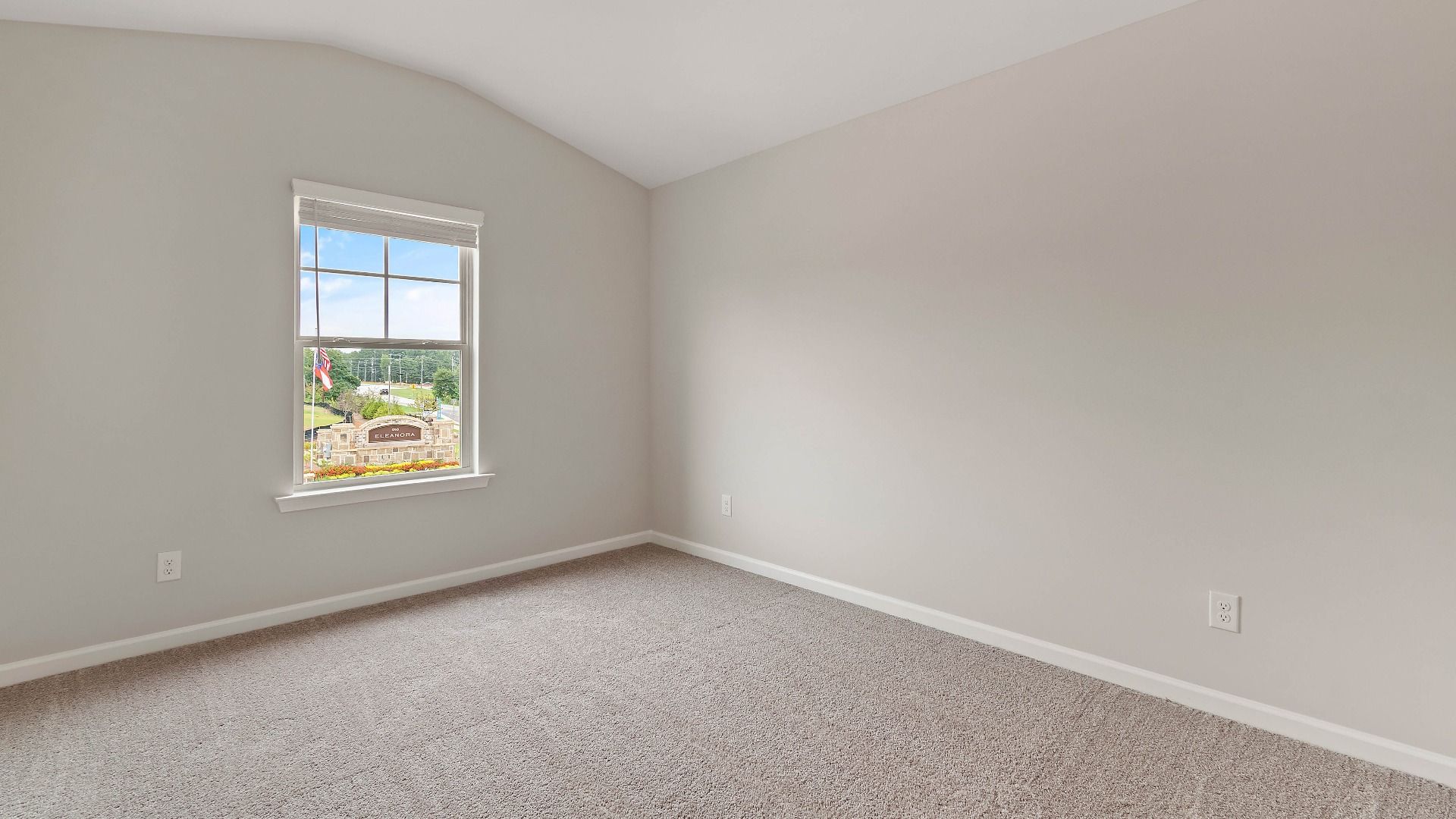 Cozy secondary bedroom with carpet flooring and a window providing natural light in the Isabella II at Adagio in Dacula, GA.