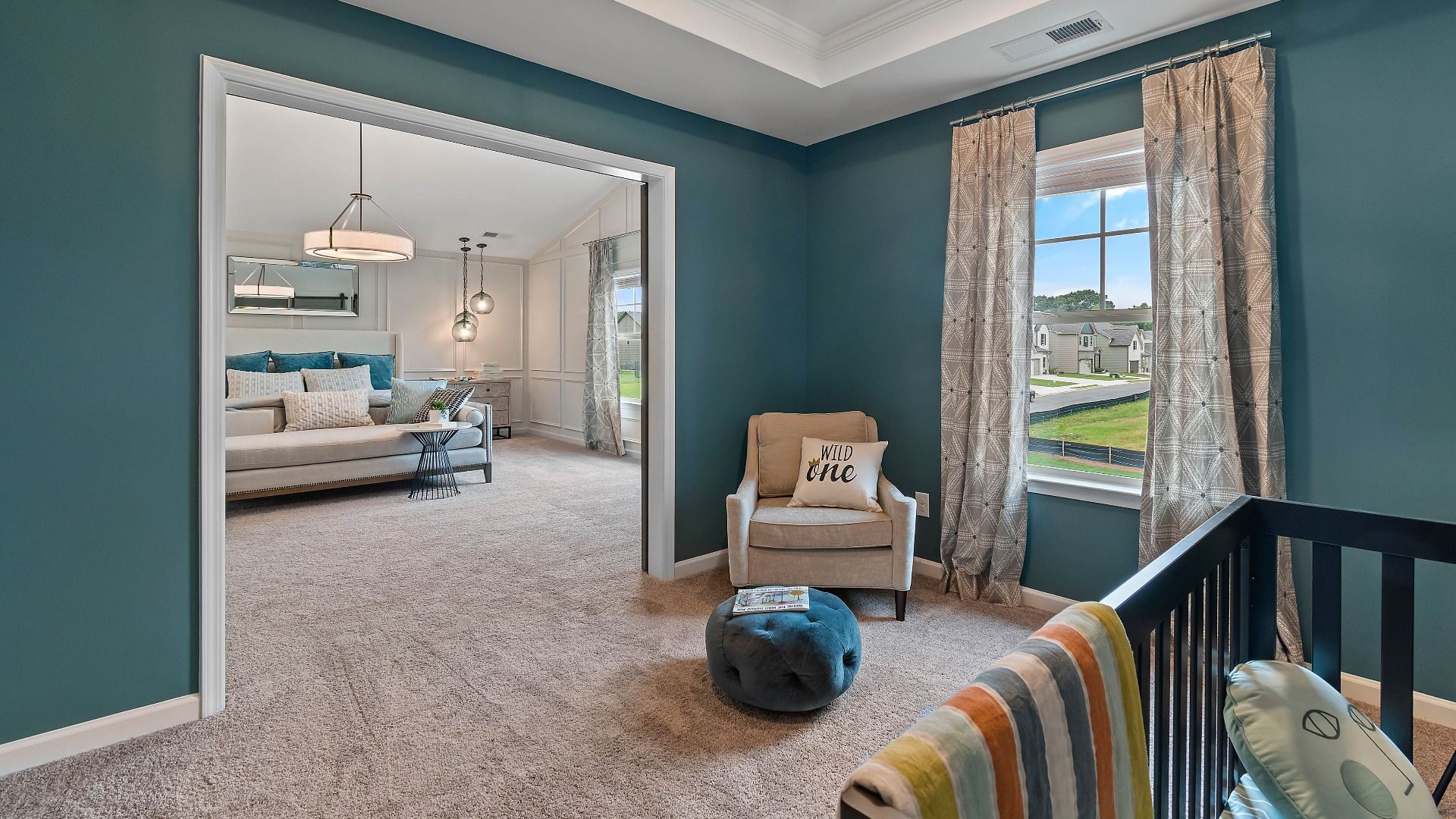 Primary suite seating room with tray ceiling, natural light, and spacious lounge area in the Isabella II at Adagio.