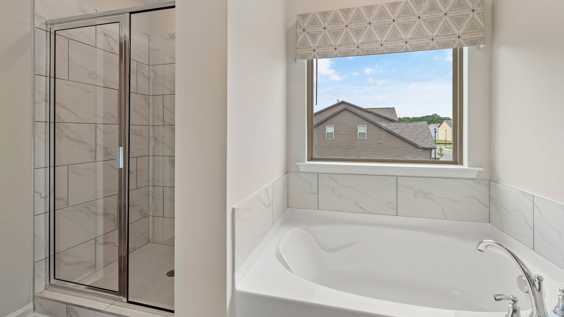 Primary bath with walk-in shower, soaking tub, modern tile finishes, and natural light in the Isabella II at Adagio.