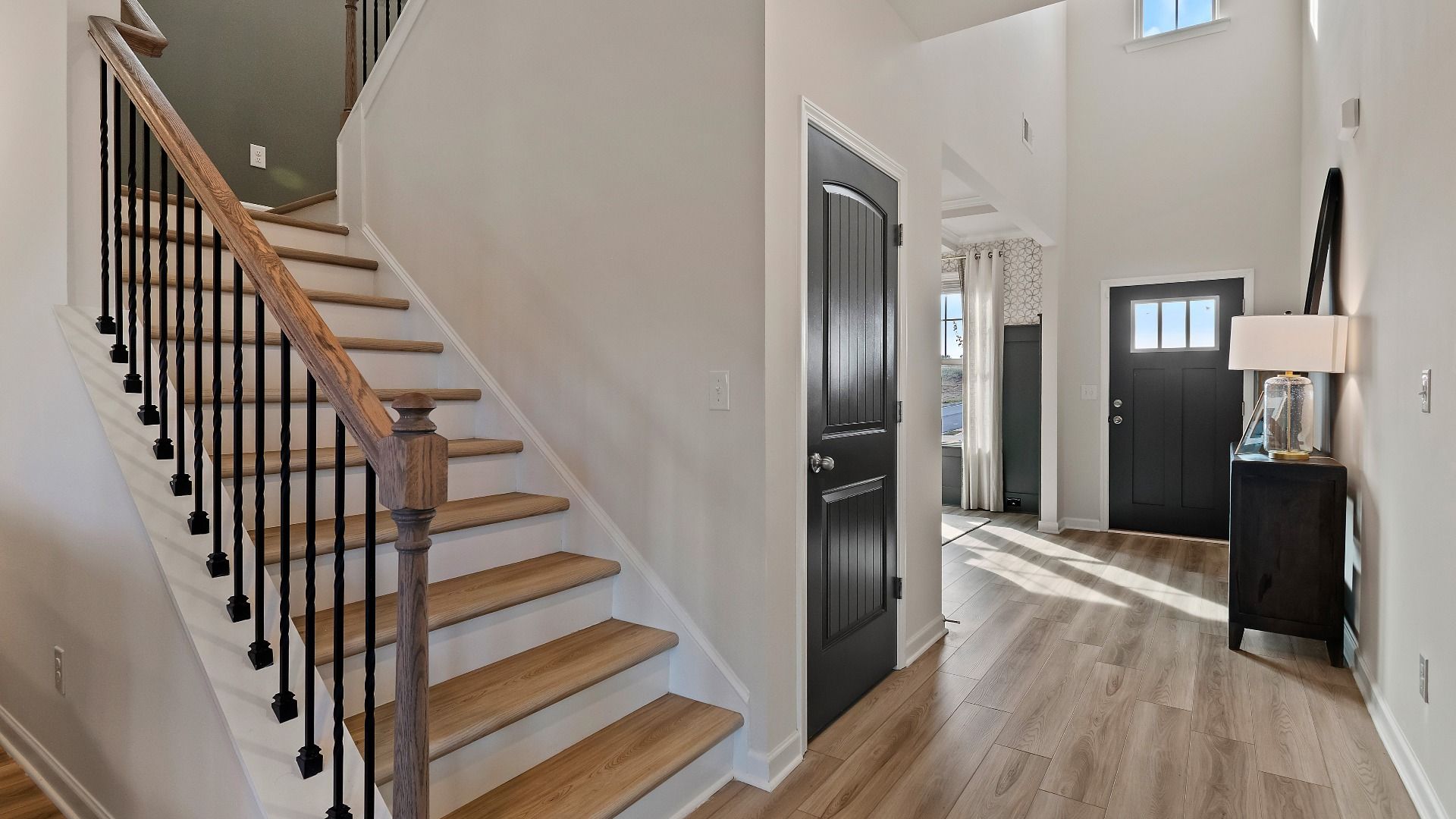 Interior staircase with decorative railing and natural light in new construction home at Adagio in Dacula, GA.